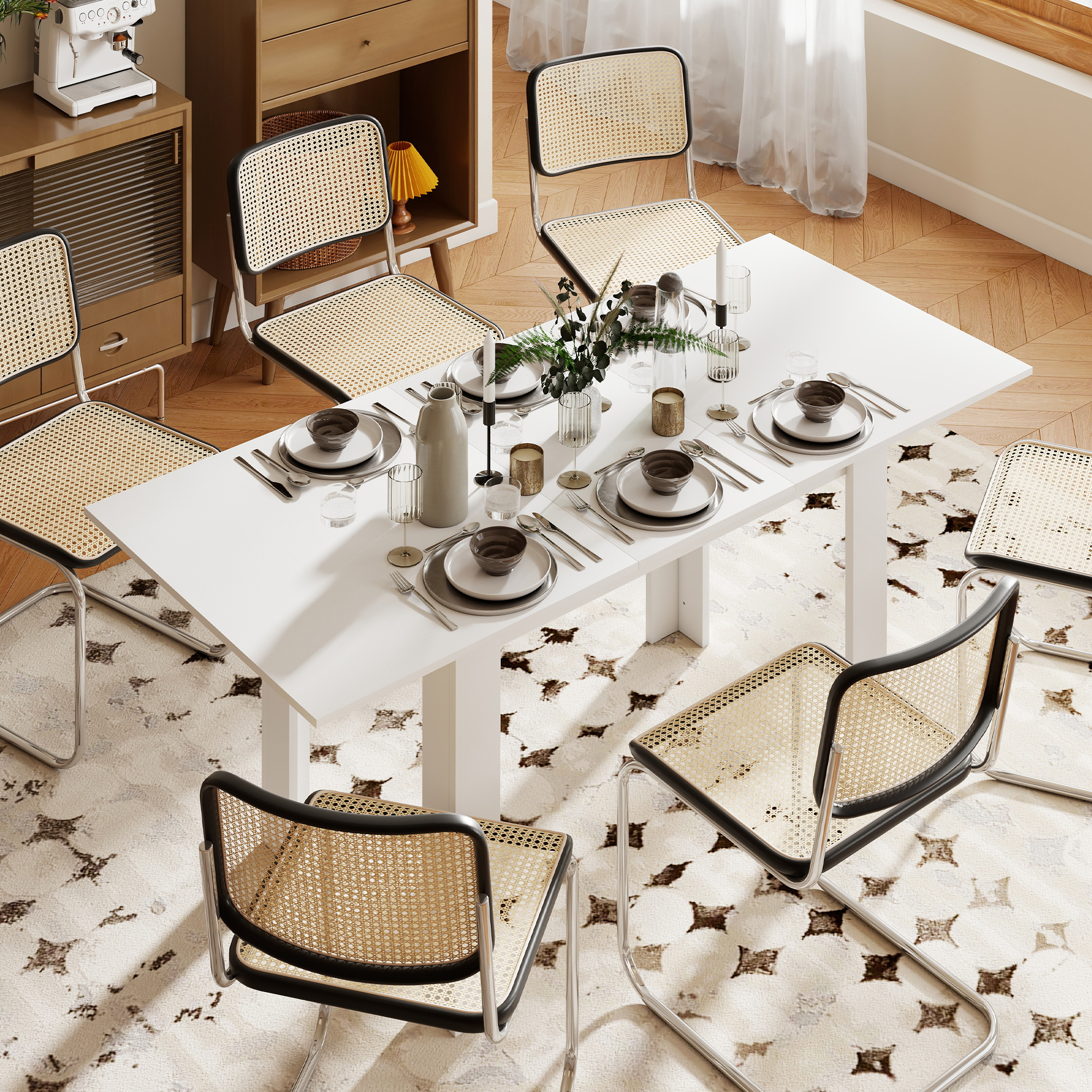 Set tavolo da pranzo con sei sedie in canna. Un tavolo bianco è apparecchiato con piatti, bicchieri e decorazioni. Sotto c'è un tappeto.