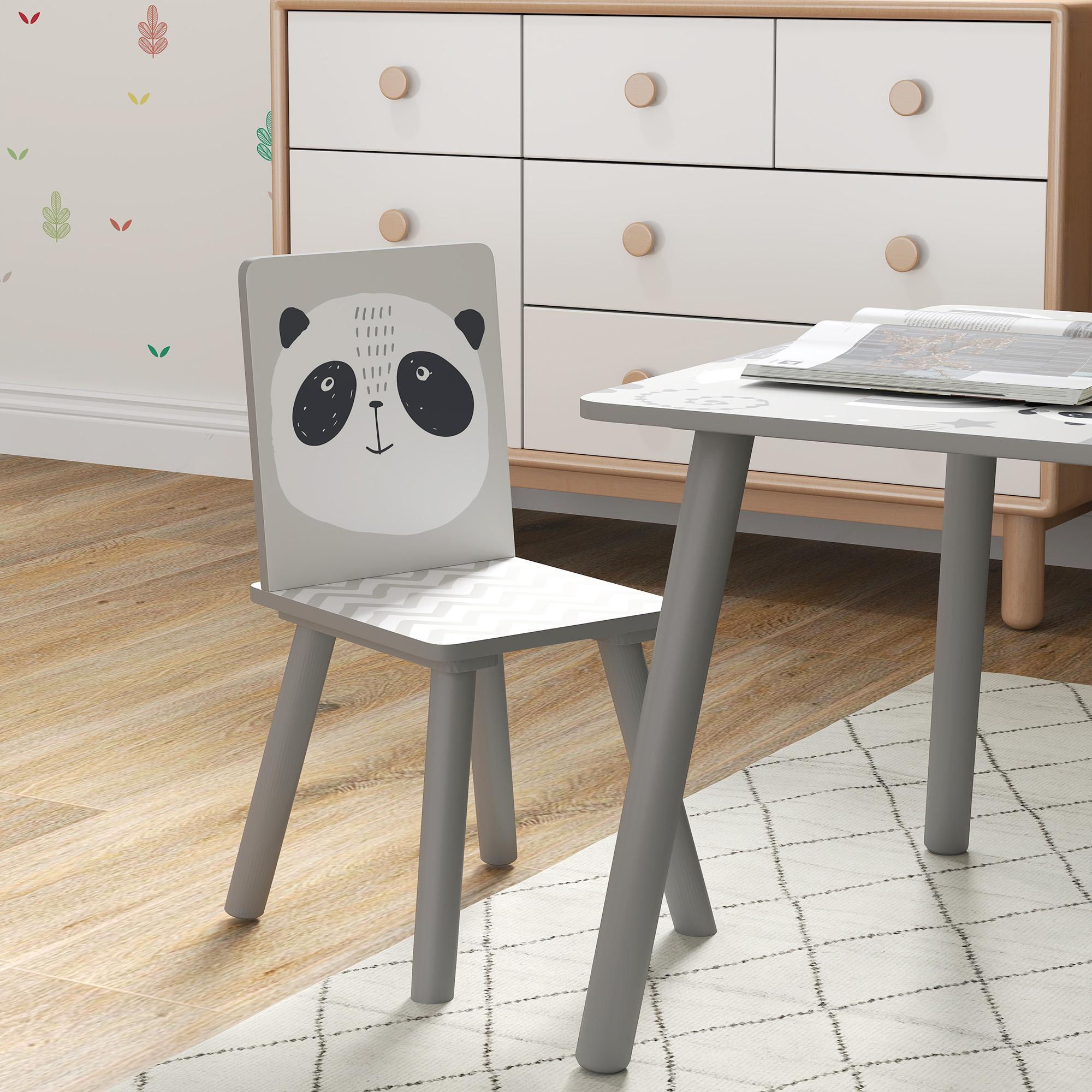 Una cameretta con sedia a forma di panda, tavolo e cassettiera bianca. La sedia ha una faccia da panda. C'è un tappeto sul pavimento.