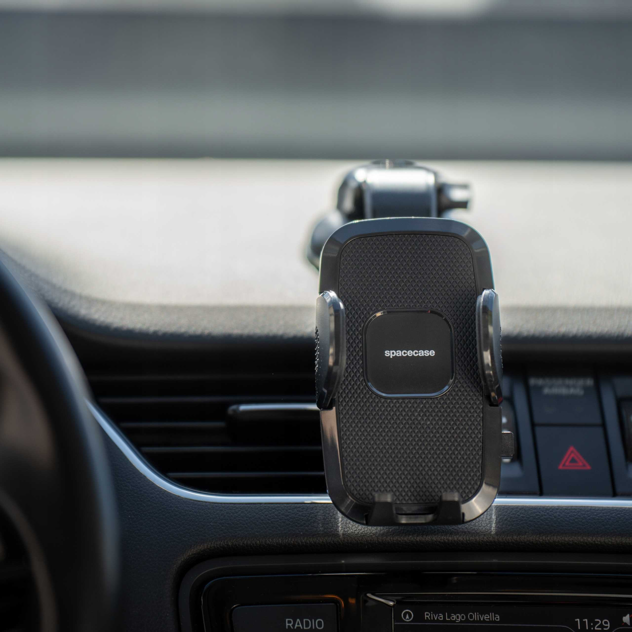 Uchwyt na telefon samochodowy jest zamontowany na desce rozdzielczej. Uchwyt jest czarny ze słowem 'spacecase'.