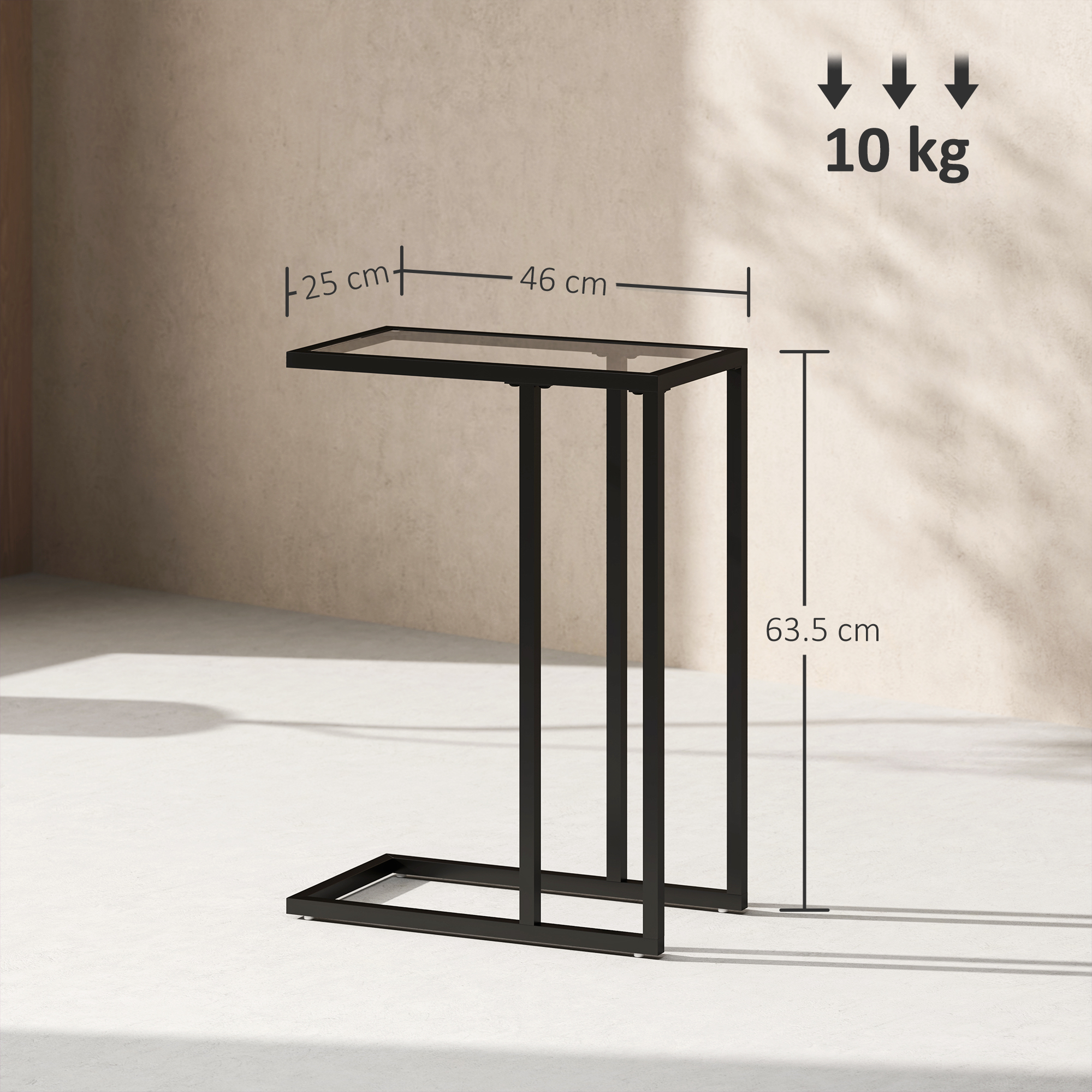 Tavolino nero con piano in vetro, dimensioni 25x46x63,5 cm. Portata 10 kg. Su pavimento chiaro con parete beige.