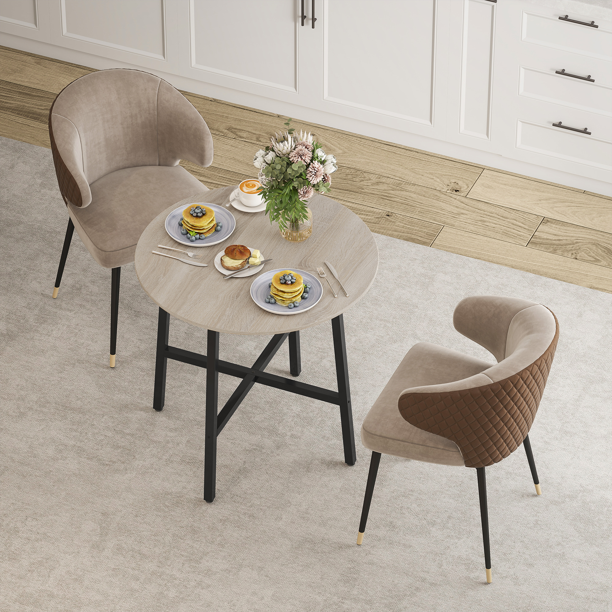 Un tavolo con pancake, caffè e fiori, circondato da due sedie beige su un tappeto grigio chiaro.