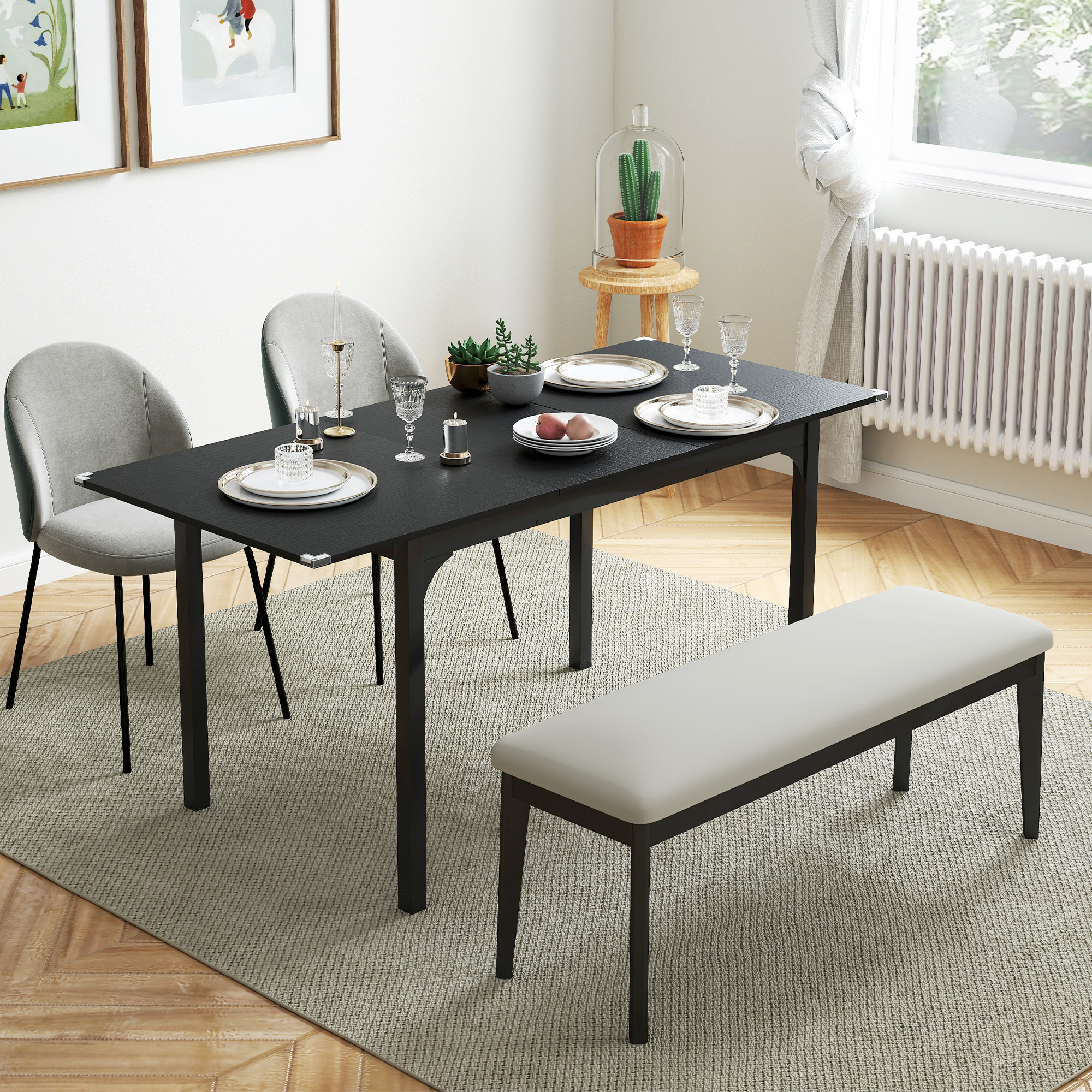 Sala da pranzo con tavolo nero, sedie grigie e panca. Piatti, bicchieri e piante sul tavolo. Tappeto e pavimento in legno.