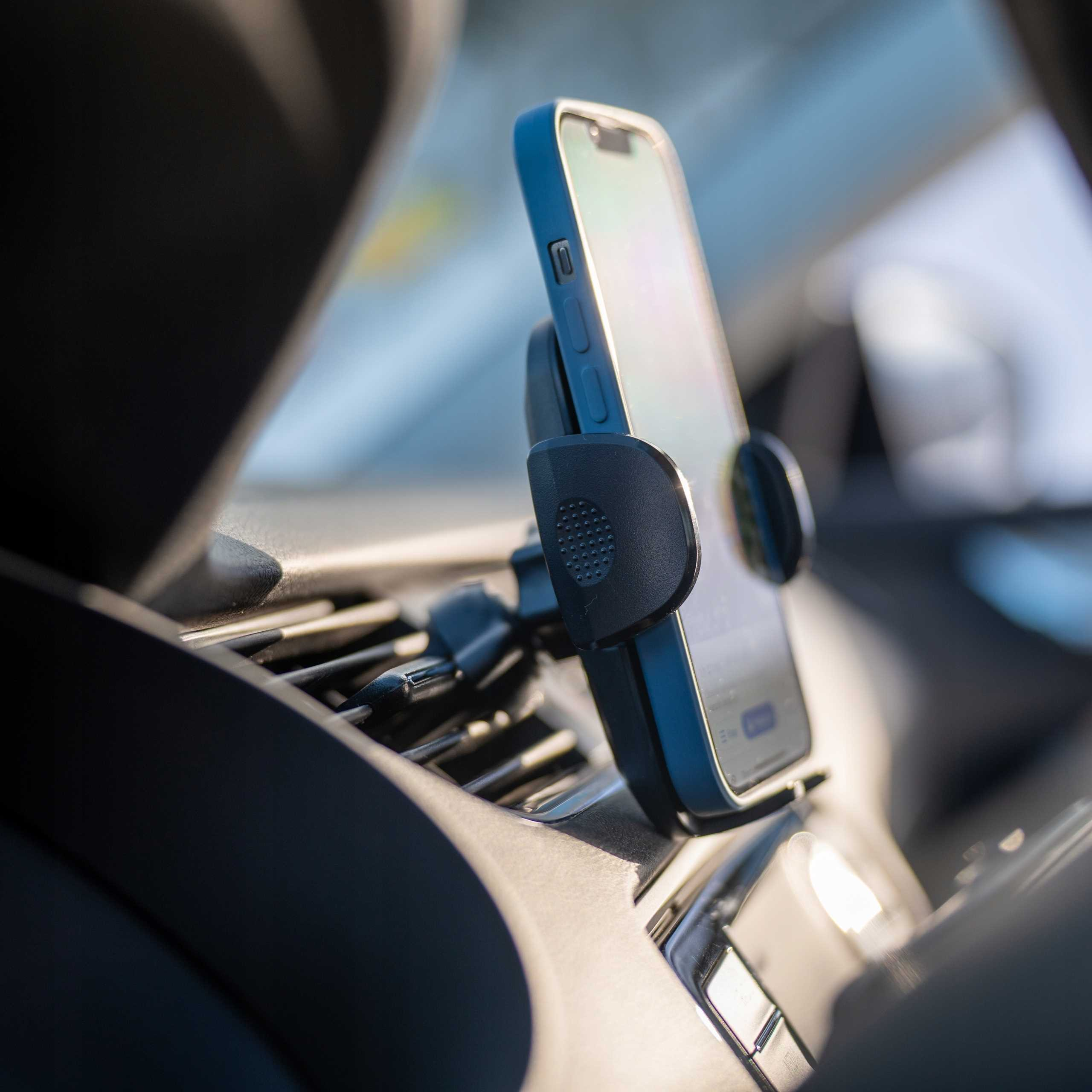Smartfon w uchwycie samochodowym zamontowany na desce rozdzielczej. Telefon jest niebiesko-czarny.