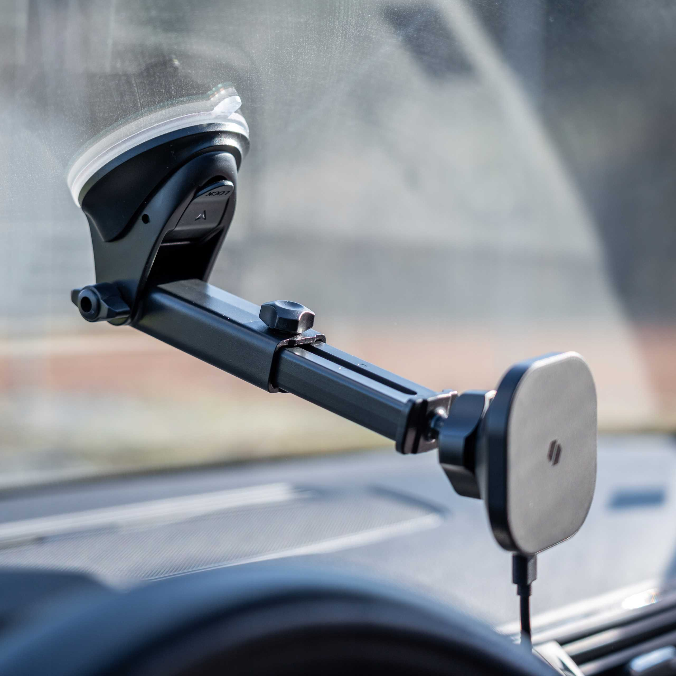 Uchwyt do telefonu samochodowego jest przymocowany do przedniej szyby. Jest czarny, z przyssawką i magnetyczną płytką.