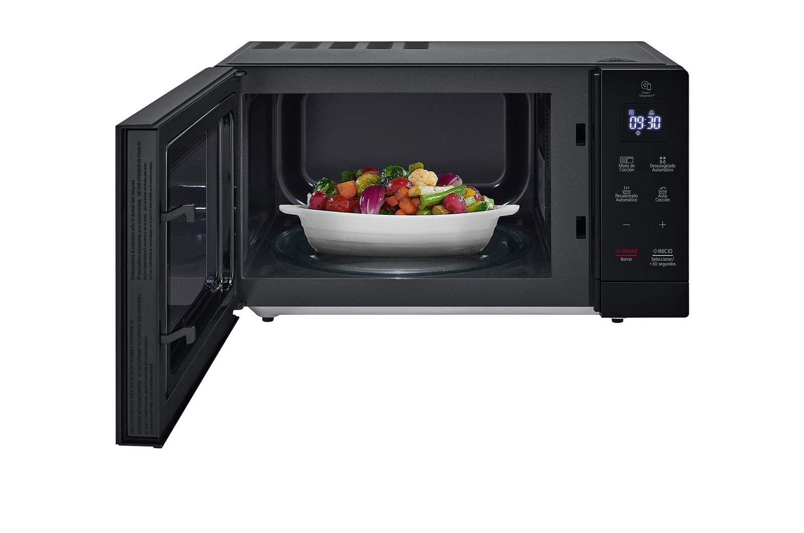 Forno a microonde con porta aperta, che mostra un piatto di verdure miste. Il display mostra l'ora. Esterno nero, interno bianco.