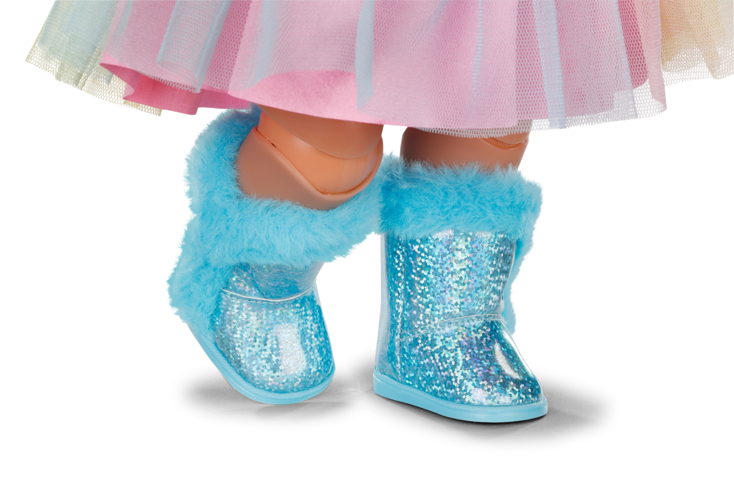 Nogi lalki w różowo-niebieskiej spódnicy, w niebieskich błyszczących butach z puszystym wykończeniem. Białe tło.