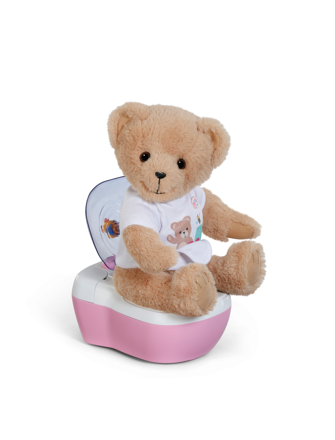 Pluszowy miś w koszulce z misiem siedzi na różowo-białym nocniku na białym tle.