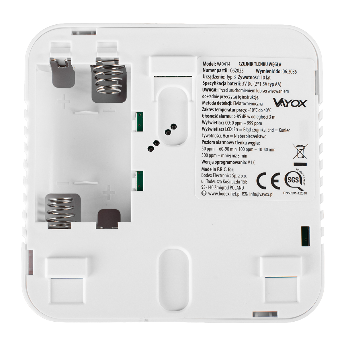 Biały detektor tlenku węgla z detalami tekstowymi, gniazdami baterii i komponentami elektronicznymi. Logo Vayox po prawej.