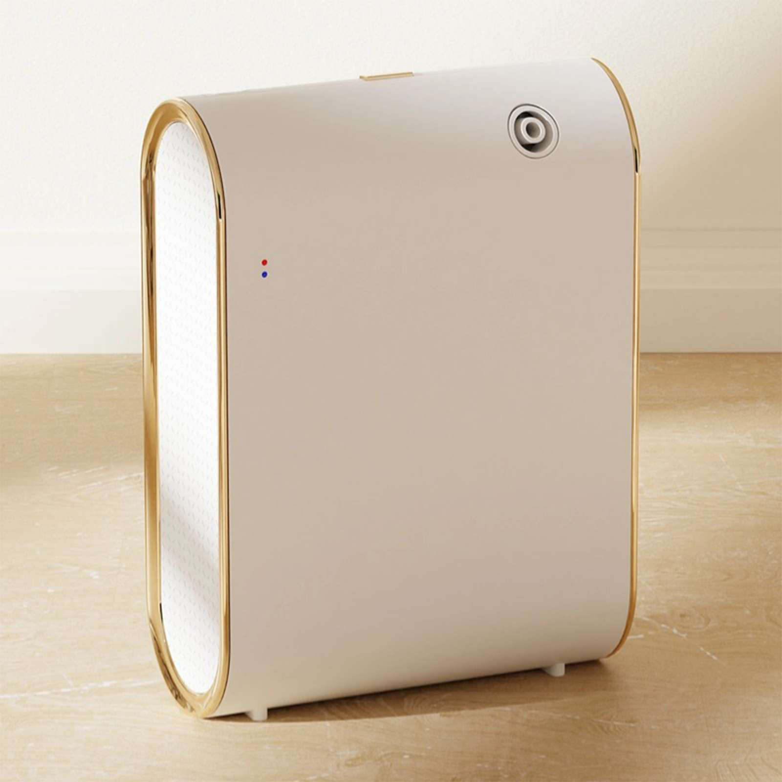 Ein weißer und goldener Luftreiniger steht auf einem Holzboden. Er hat eine Maschenfront, goldene Verzierungen und Kontrollleuchten.
