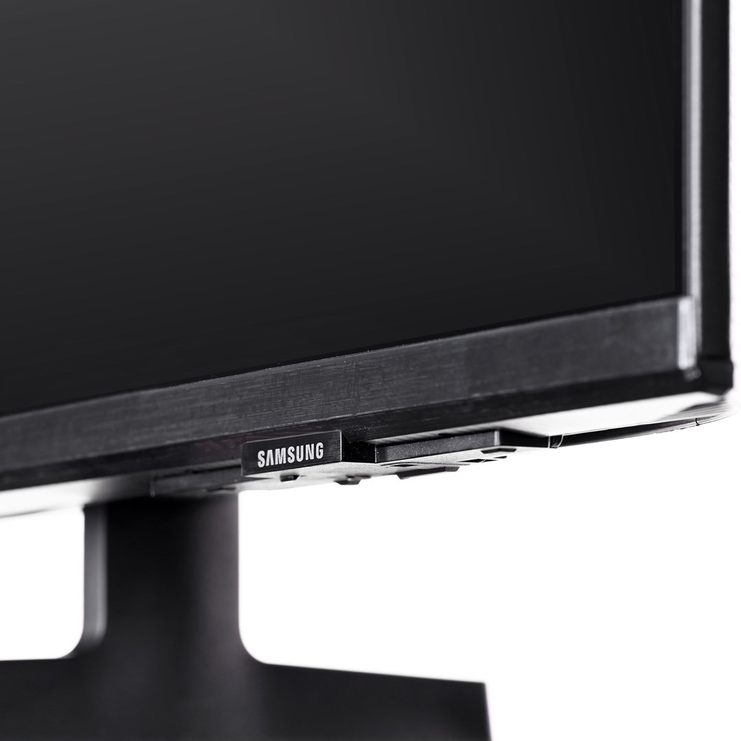 Zbliżenie czarnego monitora Samsung. Widoczna nazwa marki. Monitor na białym tle.