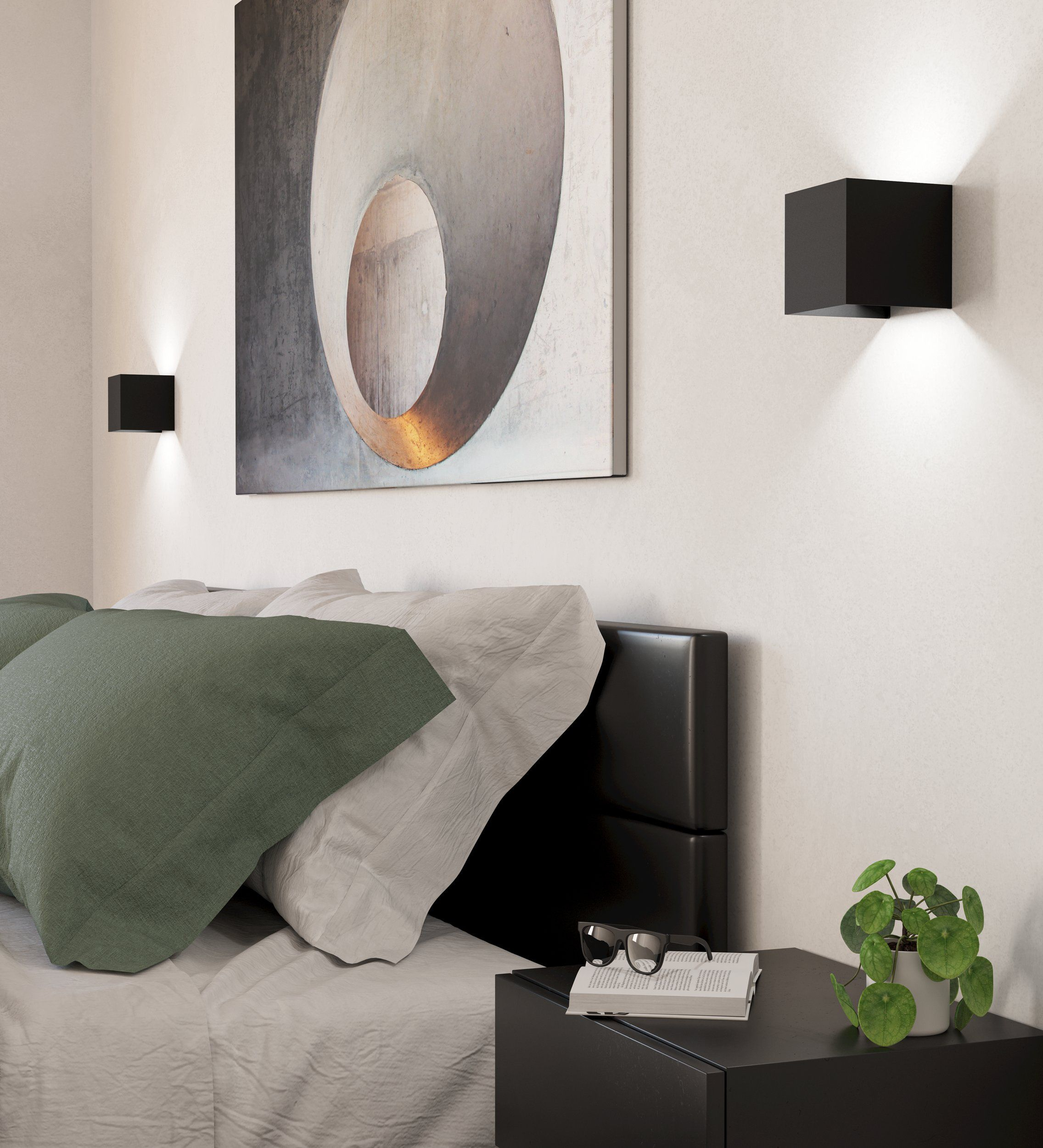 Scène de chambre avec lit, oreillers, œuvre d'art, lampes et table de chevet avec lunettes et plante.