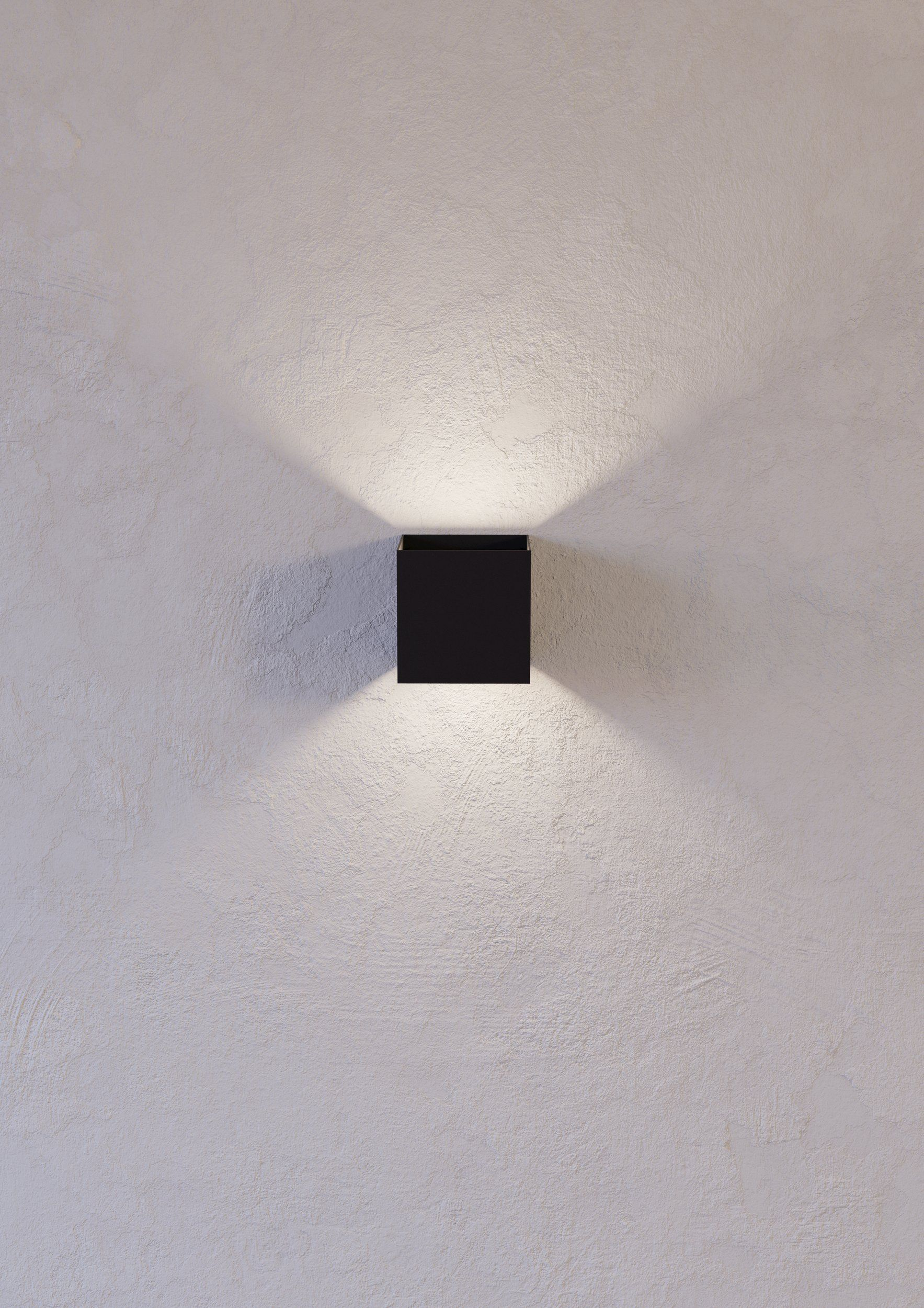Une lampe carrée noire sur un mur blanc texturé. La lumière rayonne de la lampe, créant un spot.