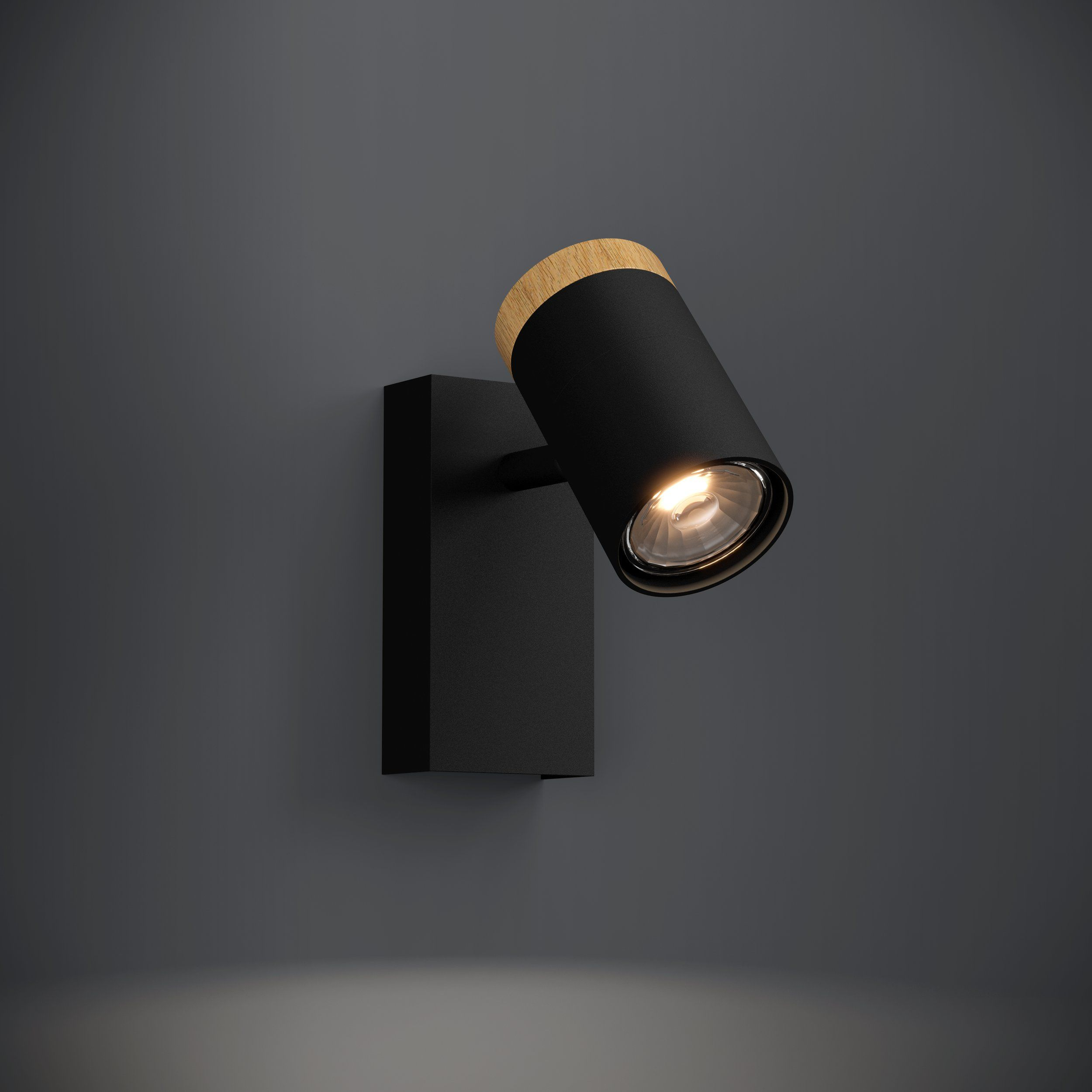 Eine schwarze Wandlampe mit Holzaufsatz. Das Licht ist an, der Hintergrund grau.