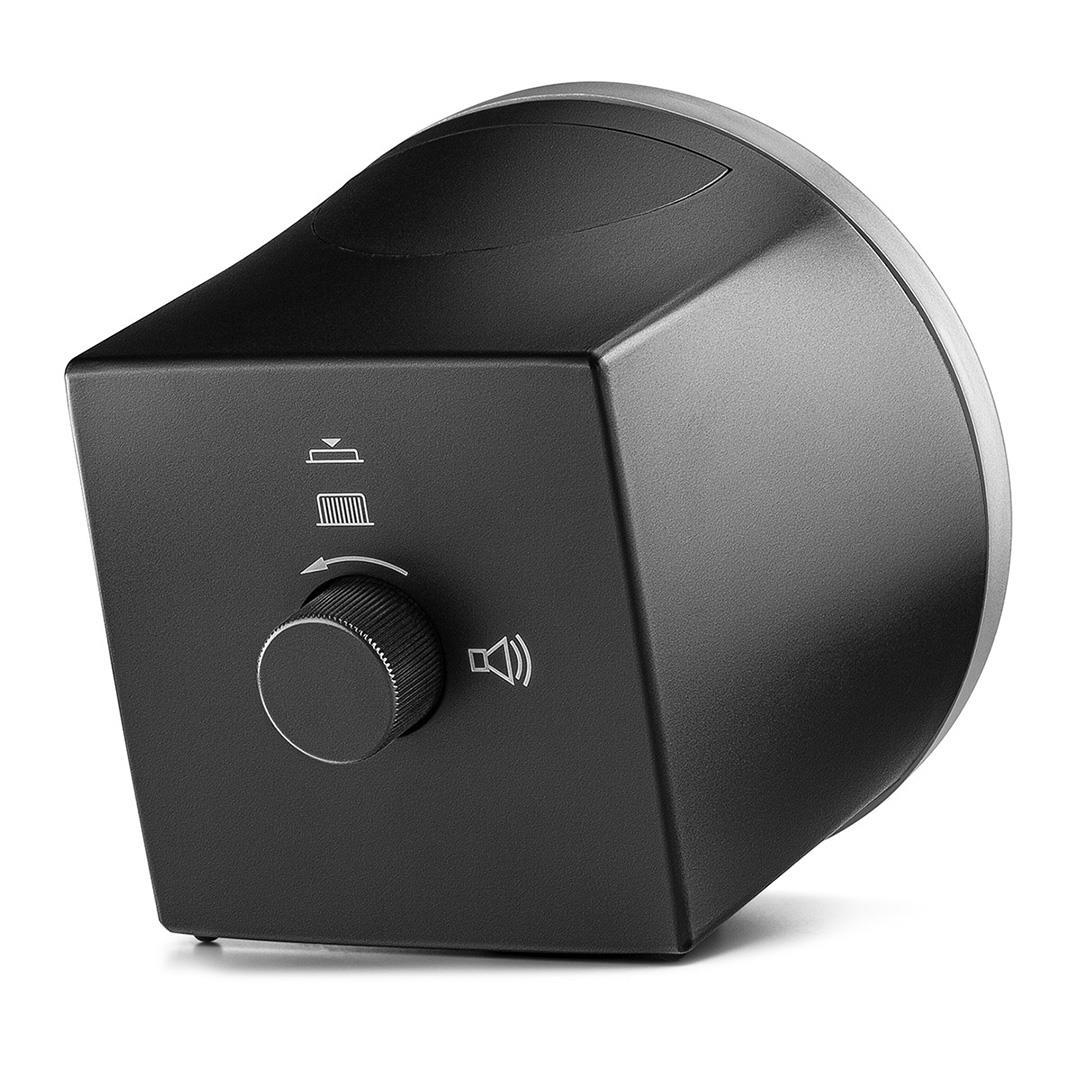 Czarny głośnik z pokrętłem głośności i ikoną głośności. Głośnik jest kątowy, z cylindrycznym tyłem i prostokątnym przodem.