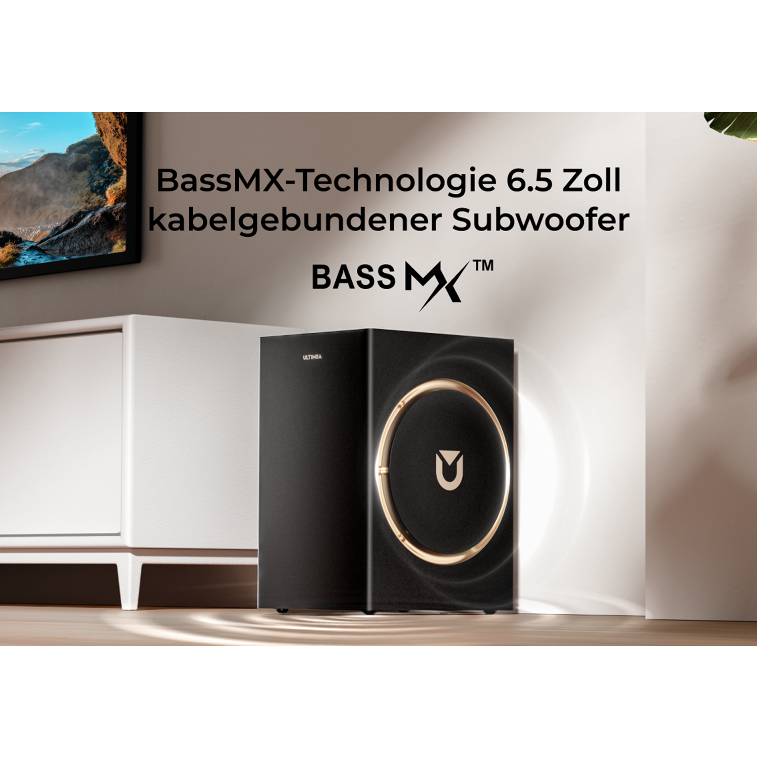 Schwarzer Subwoofer mit goldenem Ringdetail, neben einem weißen Schrank, Text an der Wand: BassMX-Technologie 6.5 Zoll kabelgebundener Subwoofer.
