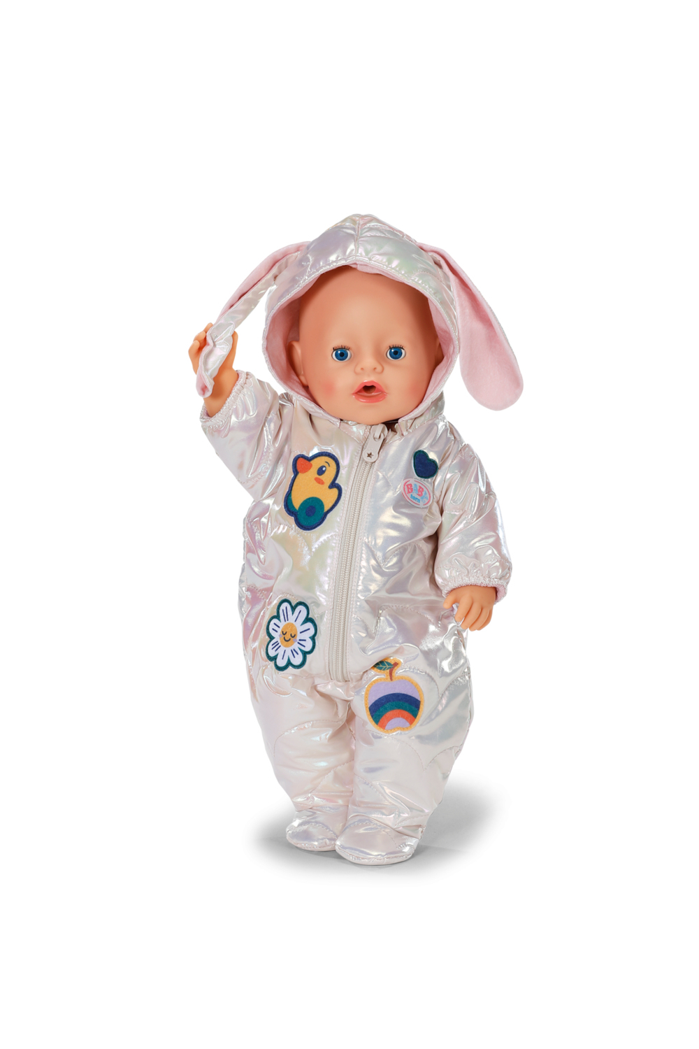 Lalka w błyszczącym, jasnym kombinezonie z kapturem i uszami królika. Lalka ma niebieskie oczy i uśmiechniętą minę.
