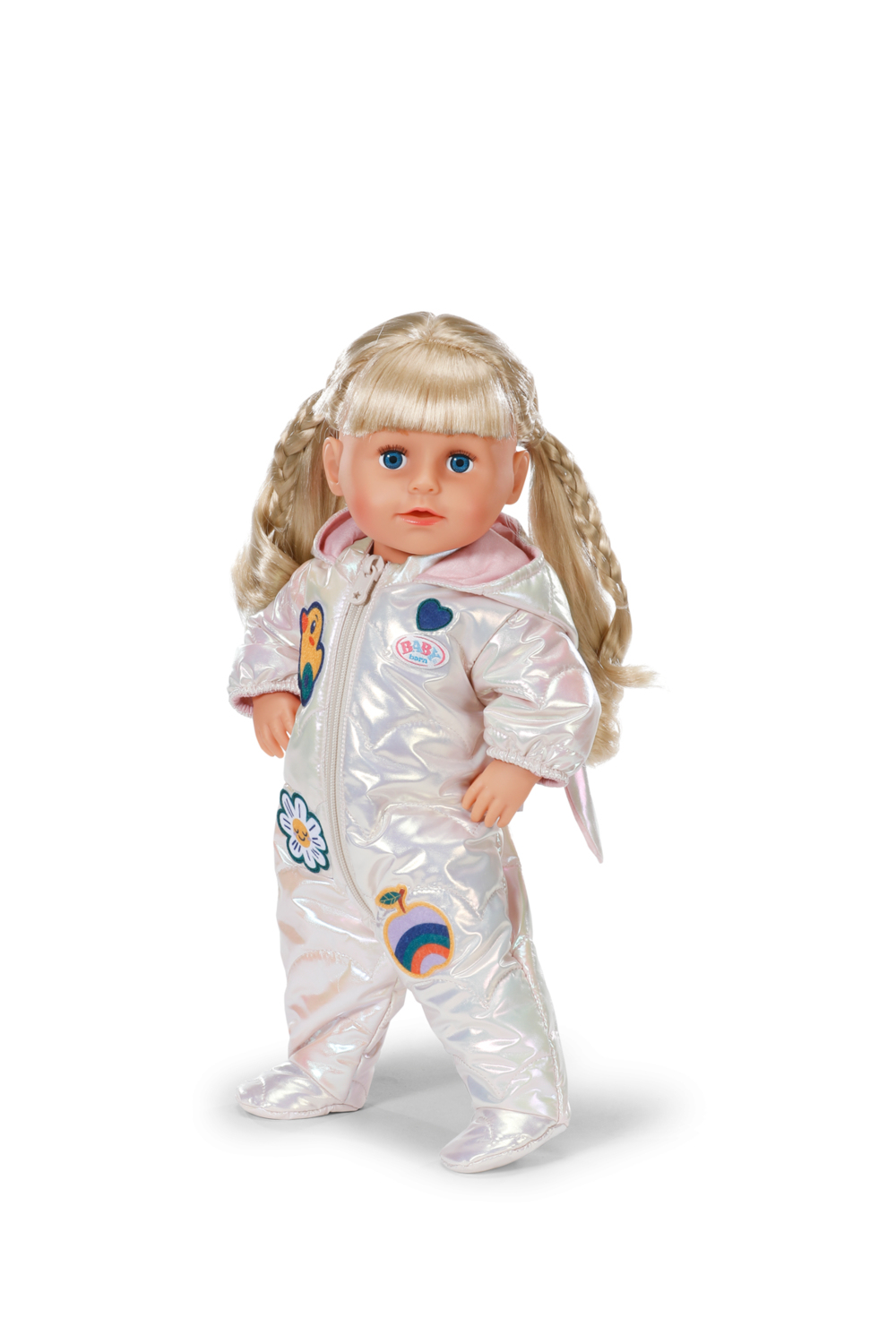 Lalka z blond warkoczami i niebieskimi oczami w białym, błyszczącym kombinezonie z kolorowymi naszywkami, na białym tle.