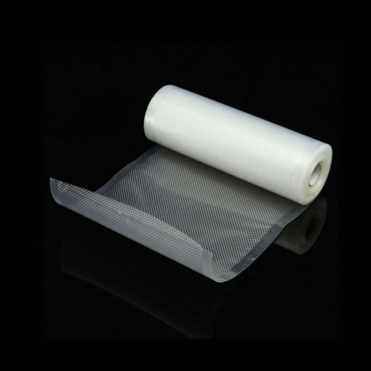 Un rollo de plástico transparente y texturizado sobre una lámina del mismo material, sobre un fondo negro reflectante.