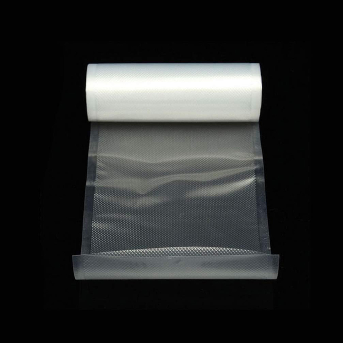 Un rollo de film transparente para sellar alimentos se desenrolla. El fondo es negro.