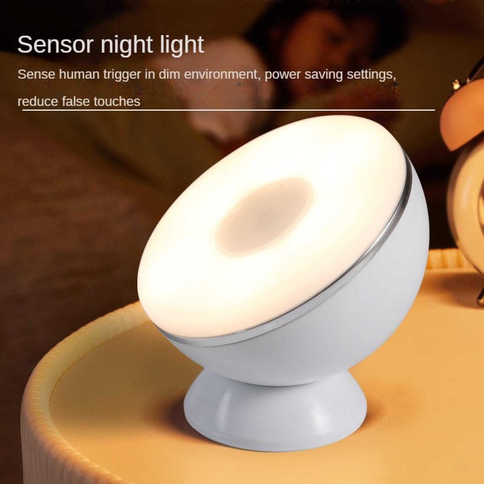 Ein weißes Sensor-Nachtlicht auf einem Tisch. Es hat einen hell leuchtenden Ring und befindet sich in der Nähe einer Uhr.