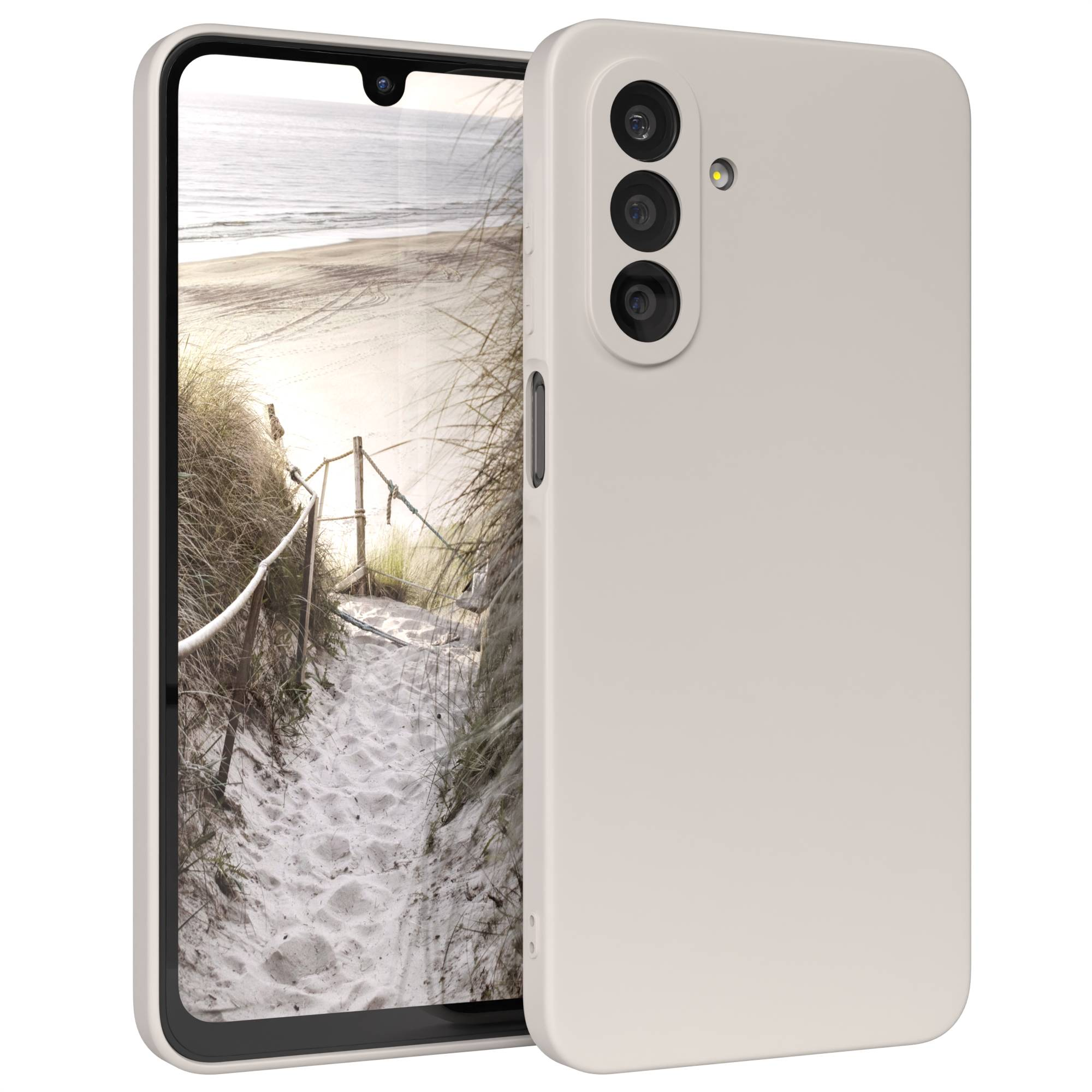 Ein Smartphone mit einer Strandszene auf dem Bildschirm. Das Telefon hat ein hellbeige Gehäuse und mehrere Kameralinsen.