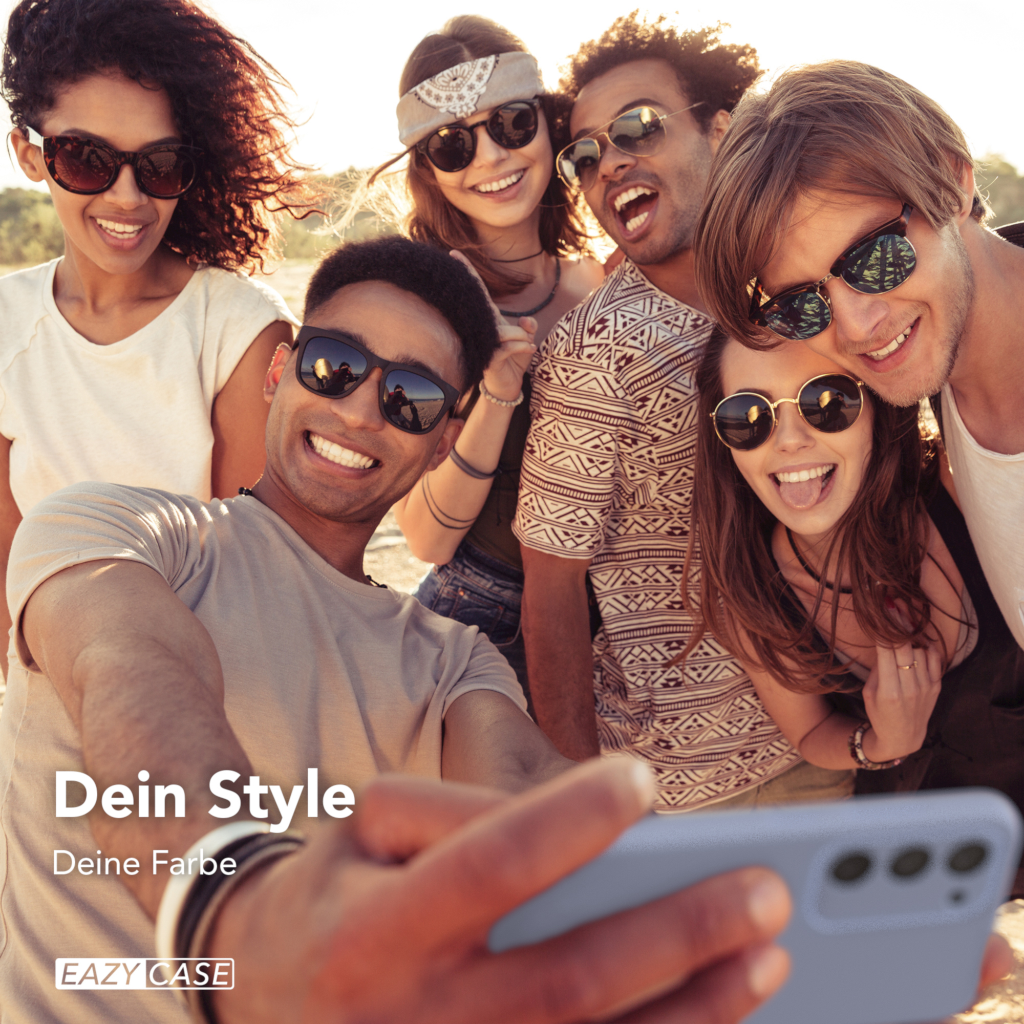 Gruppe von Freunden macht ein Selfie. Sie lächeln. Handyhülle sichtbar. Die Szene ist im Freien mit Sonnenlicht.