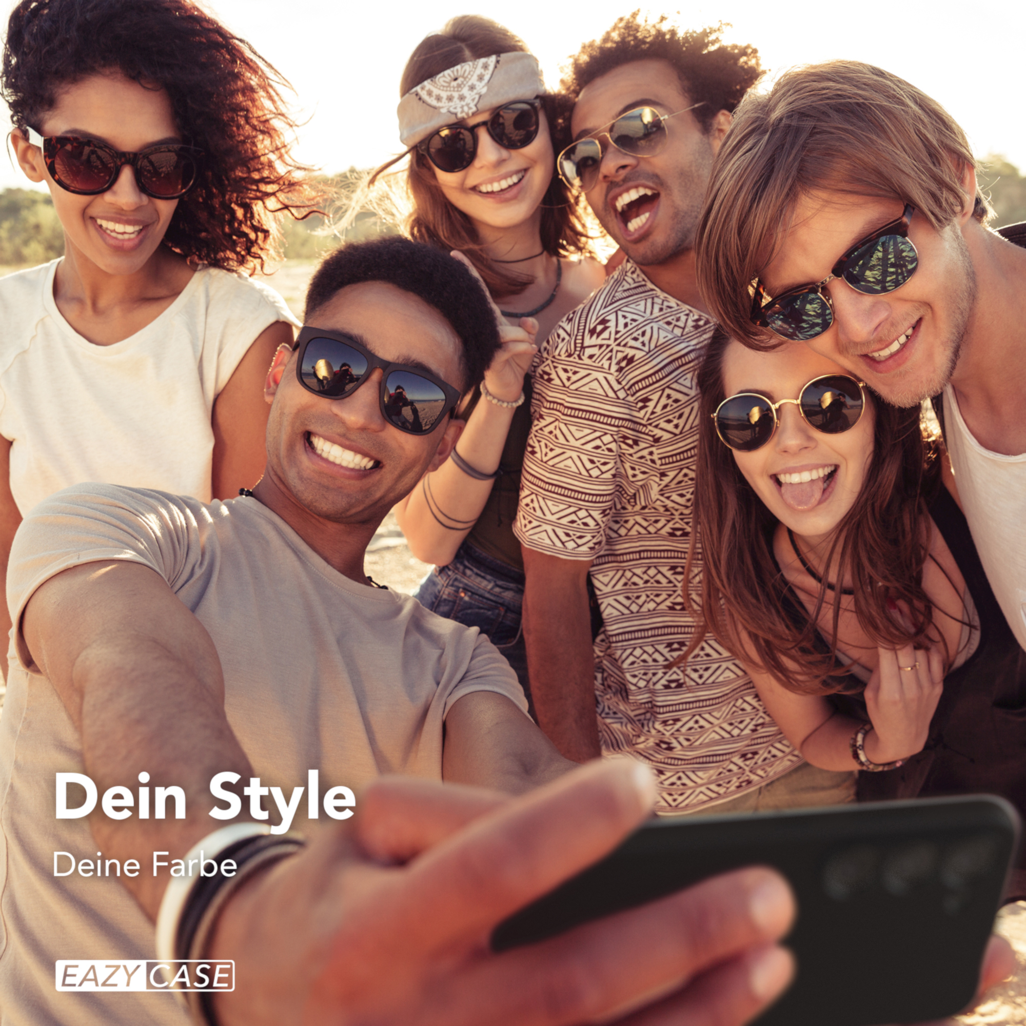 Eine Gruppe von Freunden macht ein Selfie im Freien, alle lächeln und tragen Sonnenbrillen. Eine Handyhülle ist sichtbar.