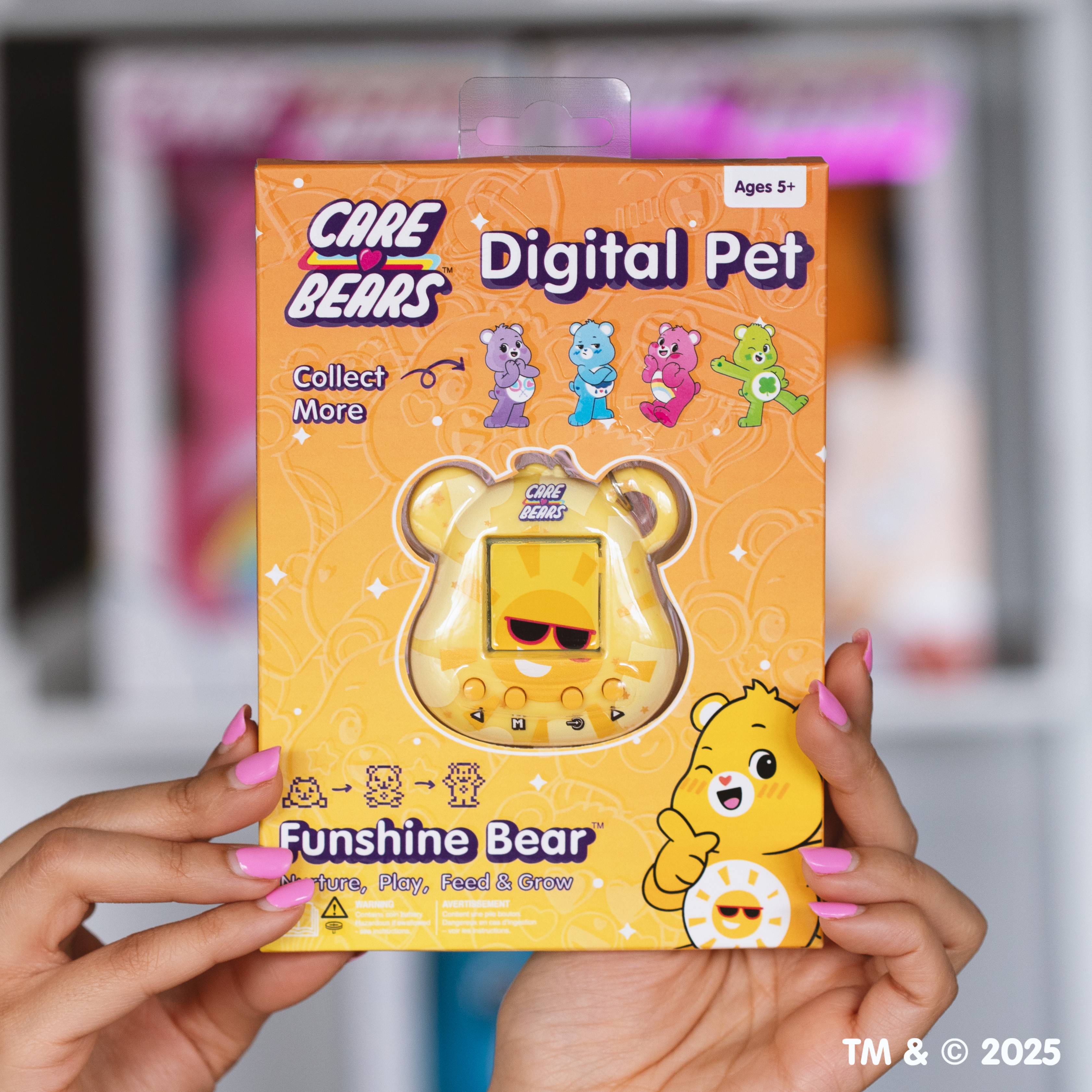 Een persoon houdt een Care Bears digitale huisdierendoos vast. De doos is geel met een Sunshine Bear-ontwerp.