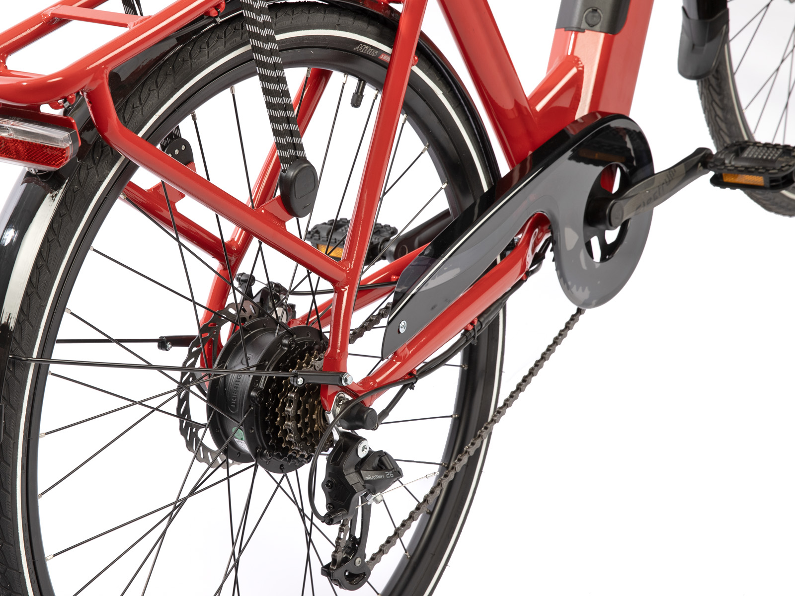 Detail van rode elektrische fiets. Achterwiel, zwarte banden, versnellingen, ketting en rode frameonderdelen tegen wit.