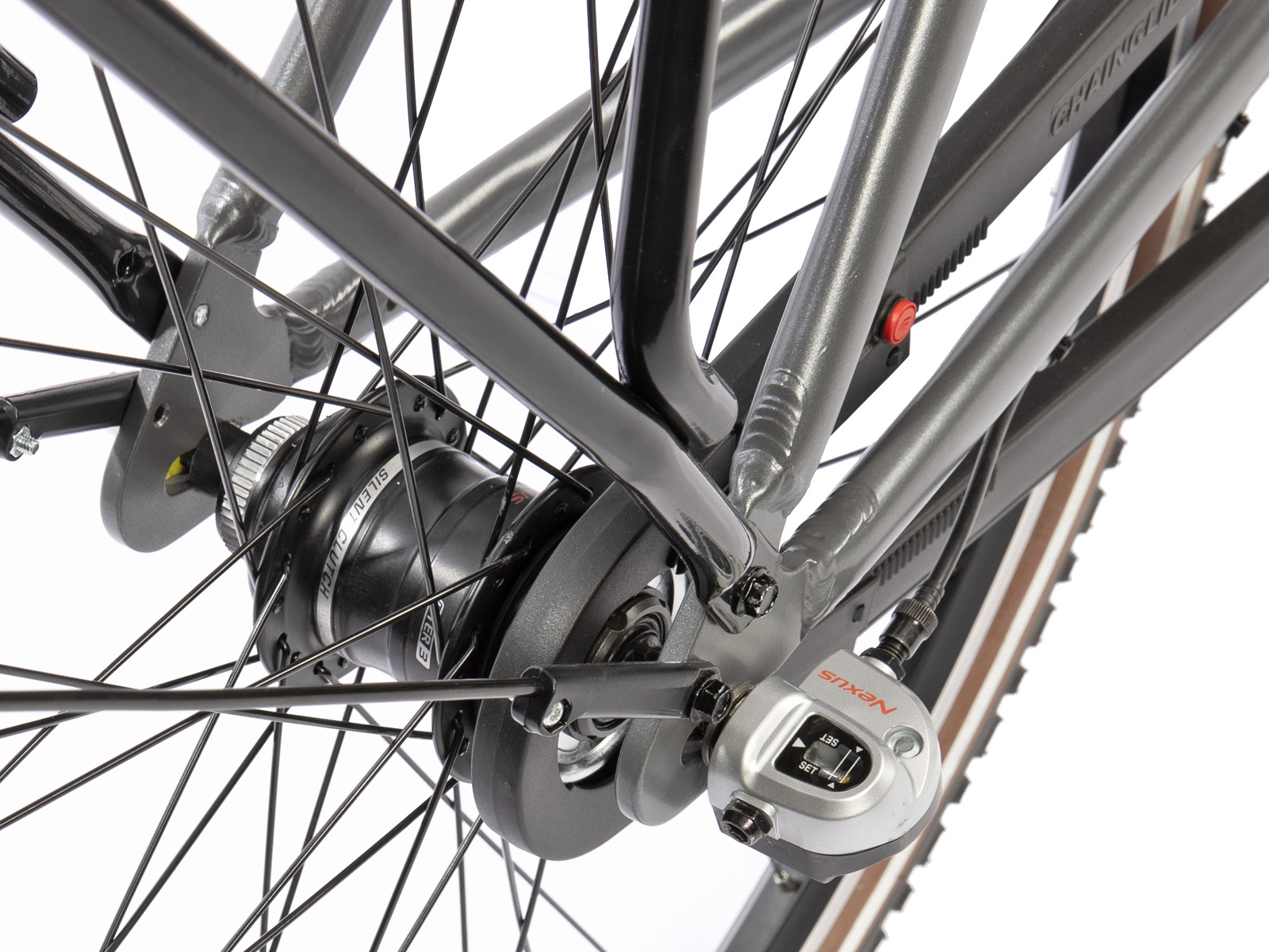 Close-up van een fietswiel en frame. Het wiel heeft veel spaken en het frame is grijs en zwart. De versnellingspook is zichtbaar.