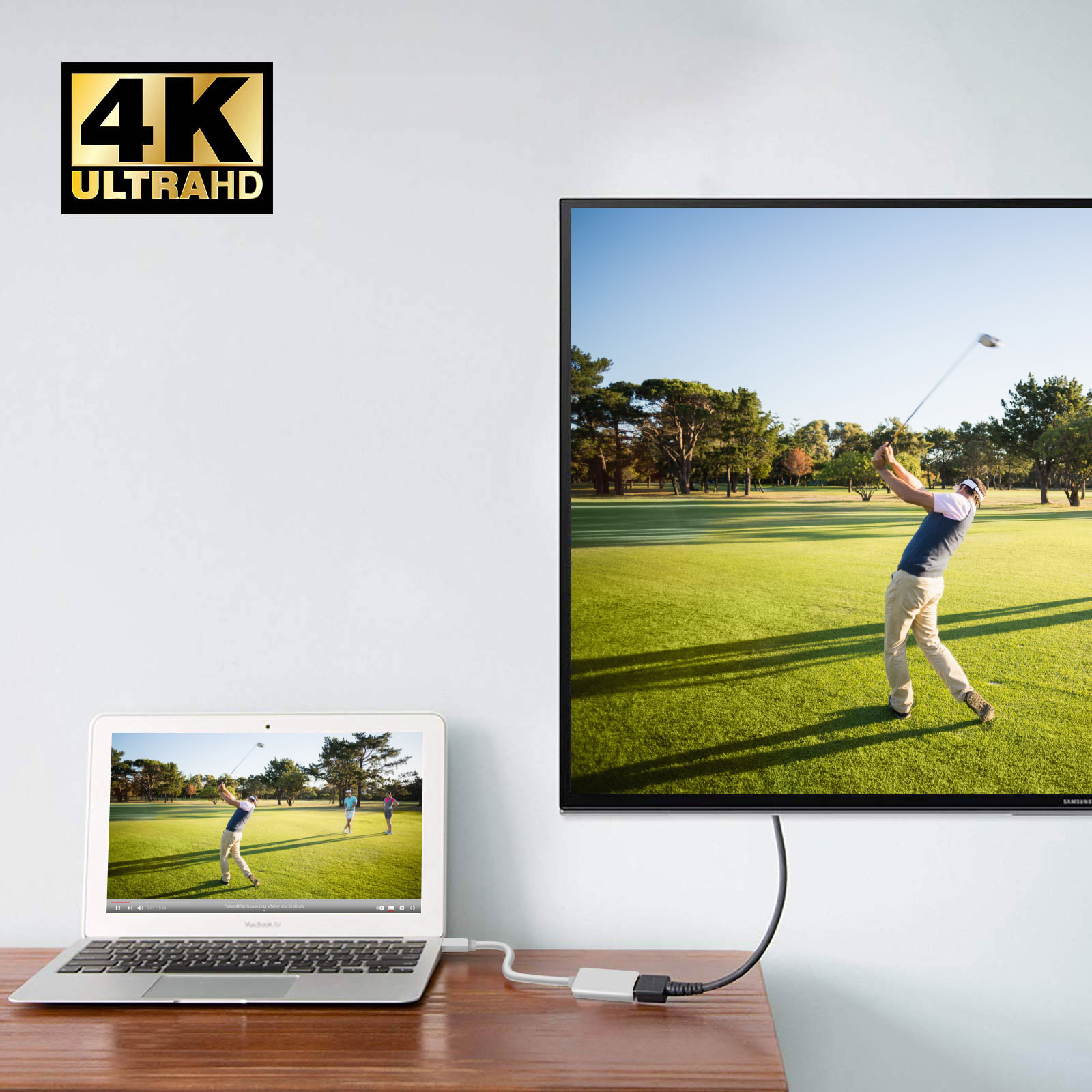 Un laptop mostra un golfista che fa swing. Una TV mostra la stessa scena. Logo 4K Ultra HD sul muro.