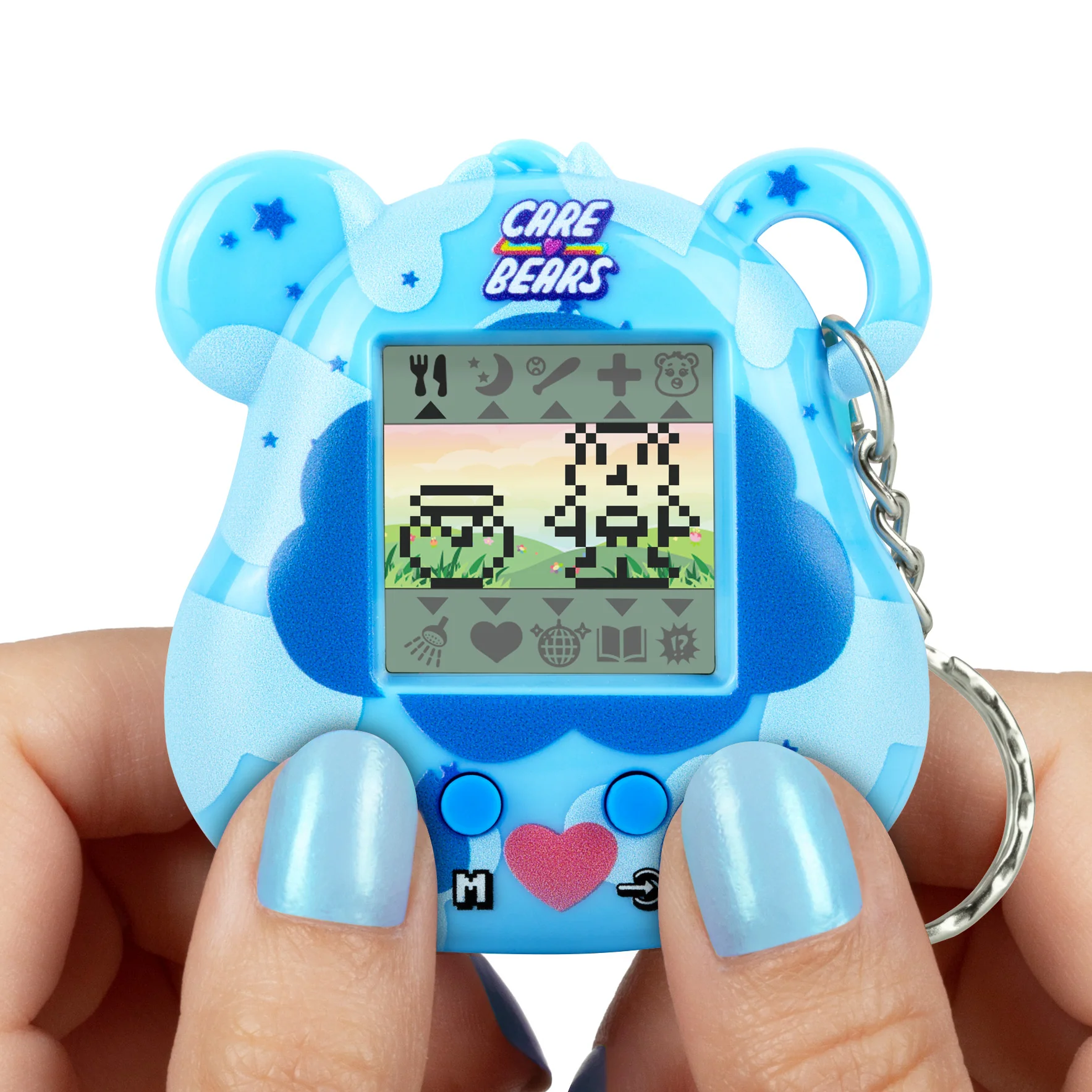 Een blauwe Care Bears Tamagotchi wordt vastgehouden door handen met blauwe nagels. Het scherm toont gepixelde karakters op een groene achtergrond.