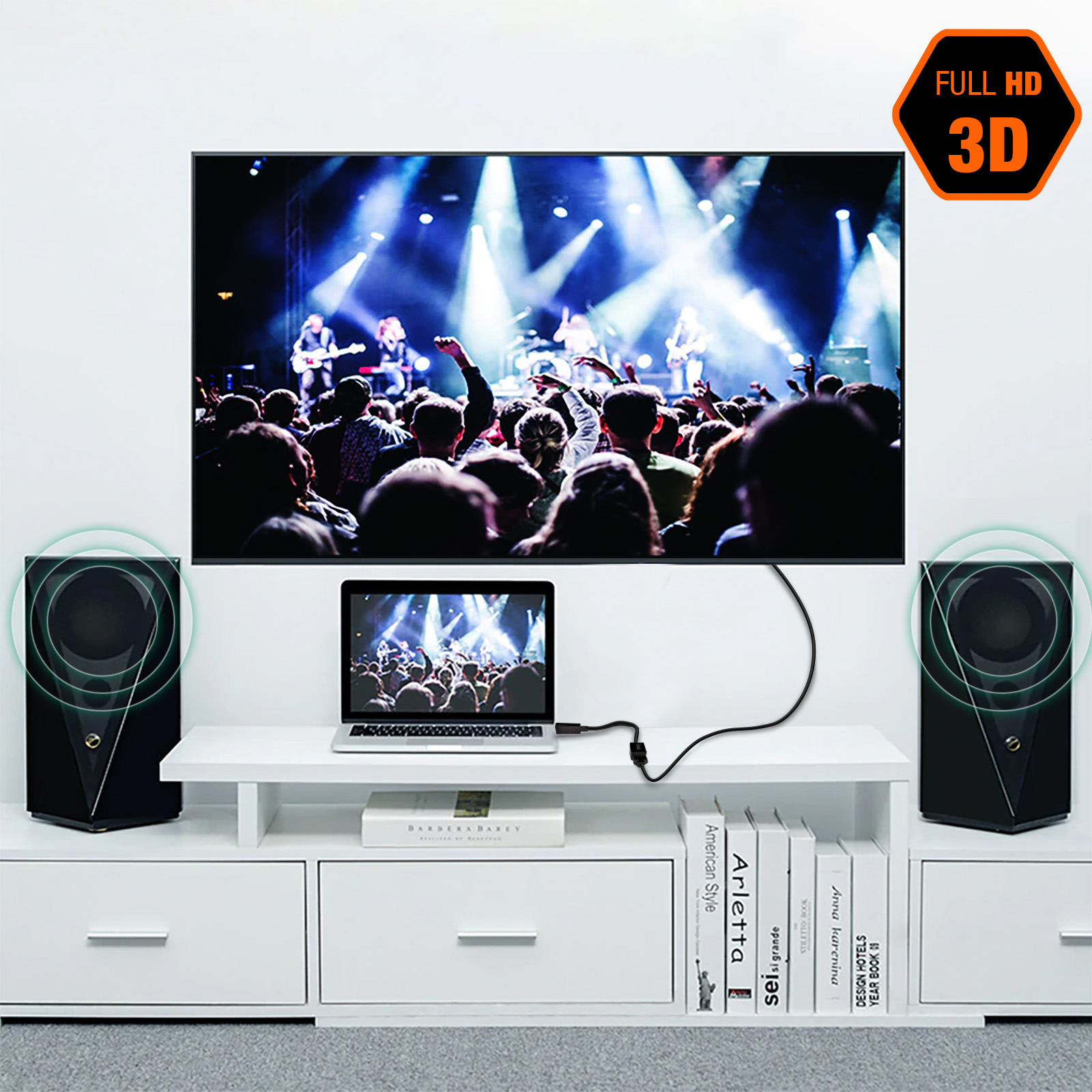 Un televisore mostra una scena di concerto. Un laptop è collegato. Gli altoparlanti affiancano lo schermo. Libri e un logo Full HD 3D sono visibili.