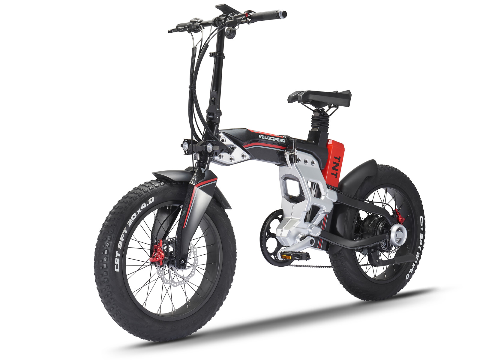 Ein schwarz-silbernes Elektrofahrrad mit breiten Reifen. Es hat einen roten Akku mit der Aufschrift 'TNT' und den Markennamen 'VELOCIFERO'.