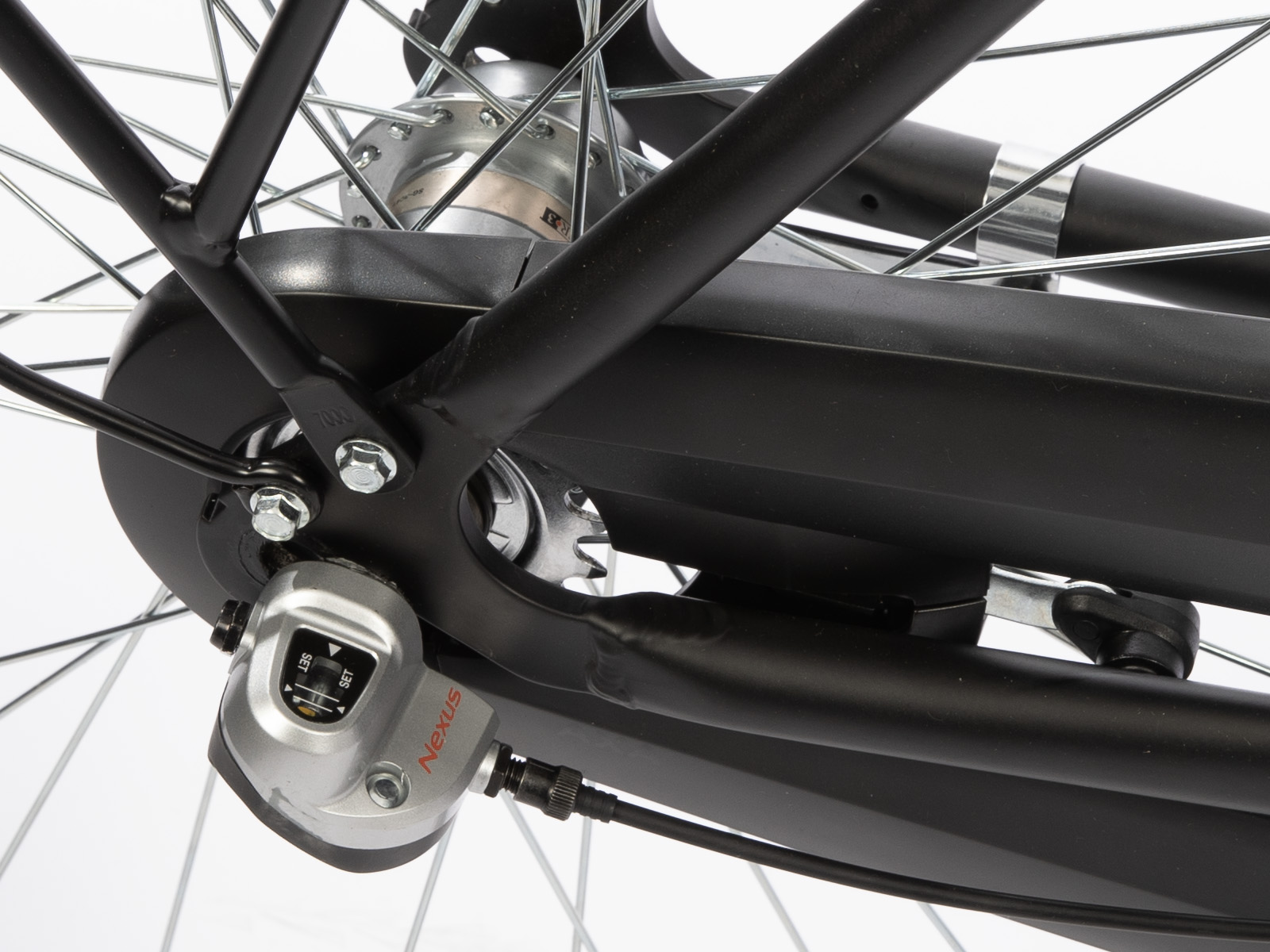 Close-up van een fietswiel en onderdelen, inclusief spaken, tandwielen en het Nexus-versnellingssysteem, tegen een witte achtergrond.