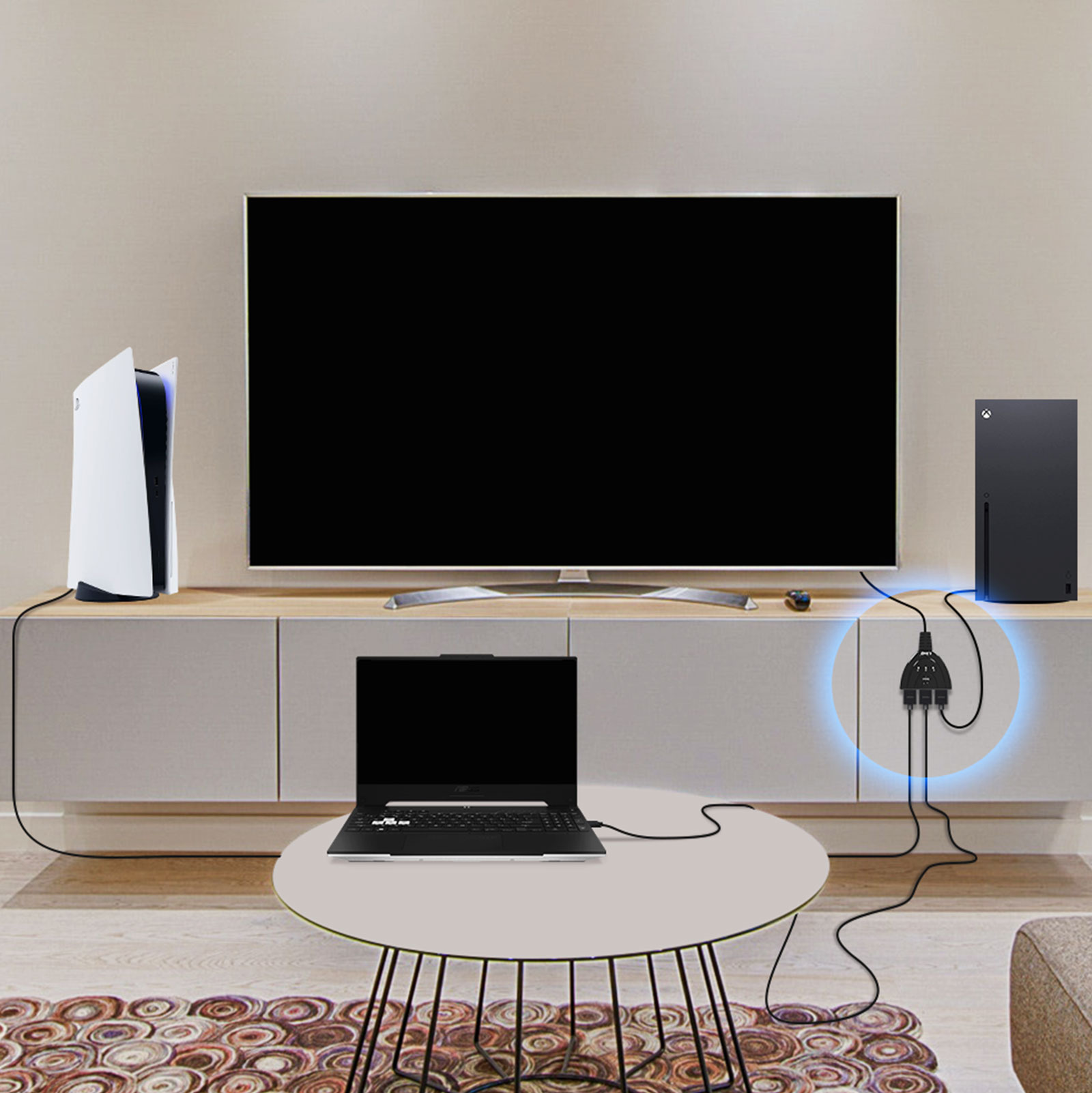 Ein Setup mit Fernseher, PS5, Xbox und Laptop. Sie sind über einen Switch verbunden. Das Setup steht auf einem hellen Schrank.
