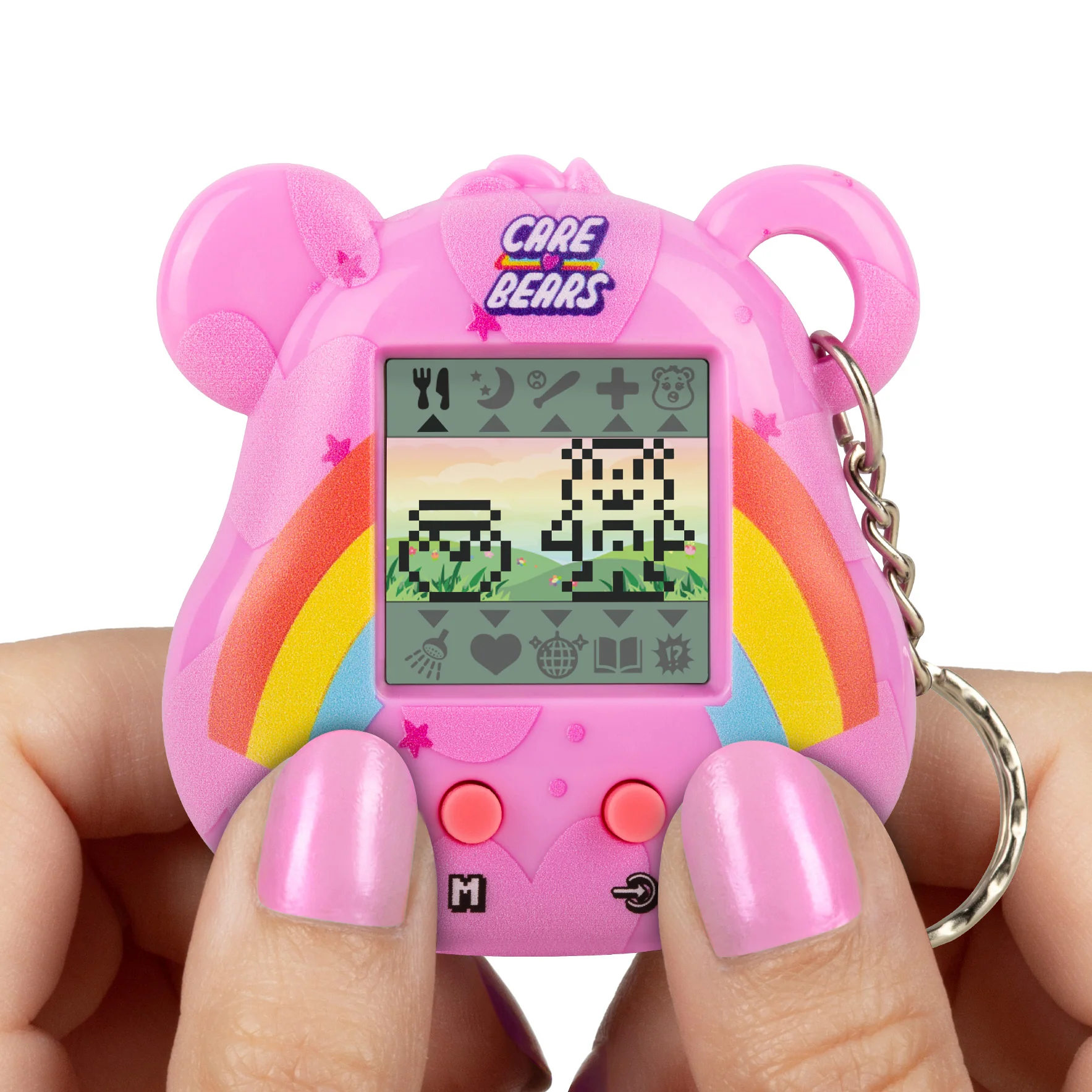 Een roze Care Bears Tamagotchi wordt vastgehouden door handen met roze nagels. Het scherm toont gepixelde beren en een regenboog.