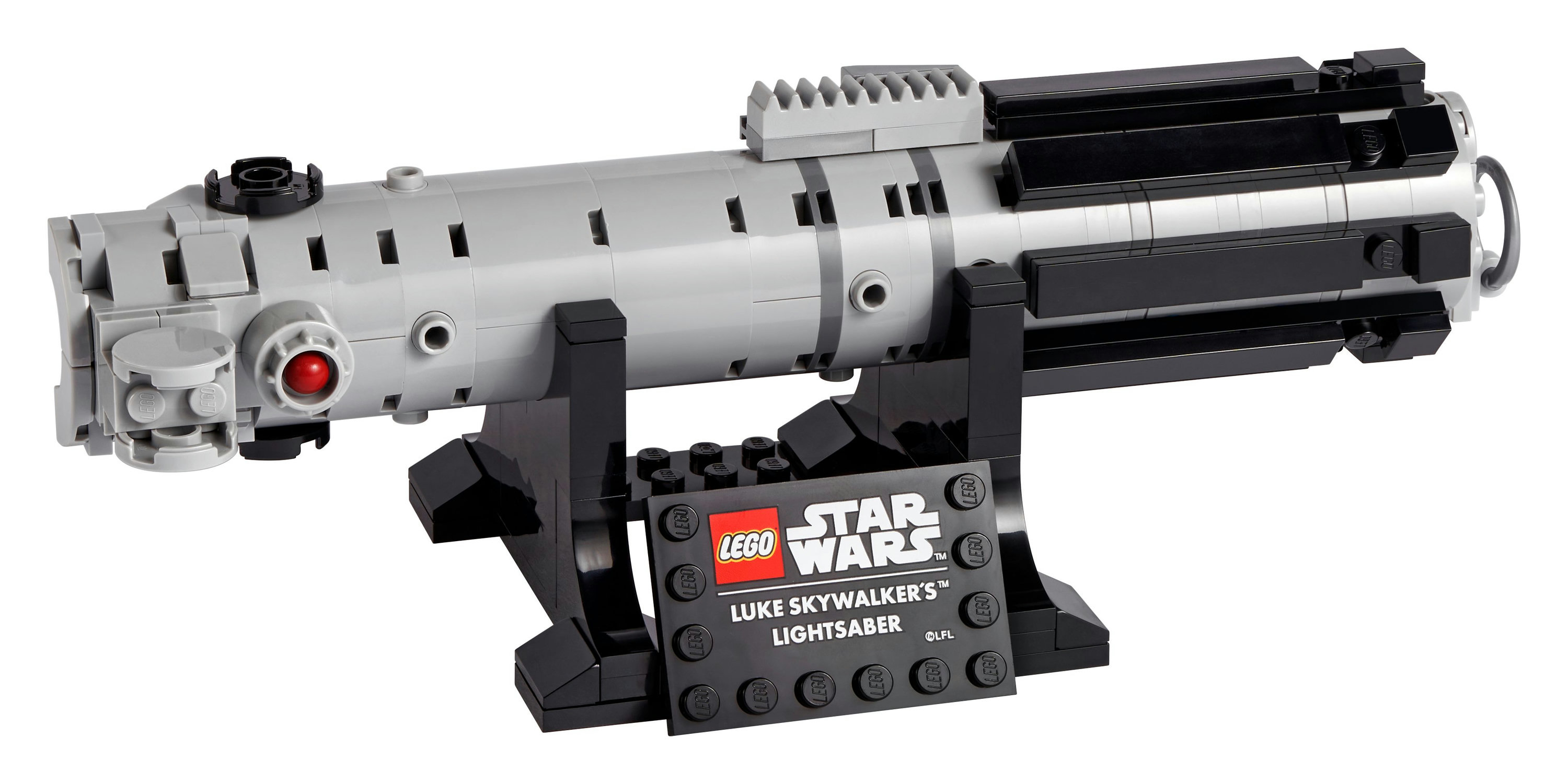 Un set LEGO Star Wars Spada laser di Luke Skywalker. È grigio chiaro, nero e ha un pulsante rosso. È su un supporto nero.