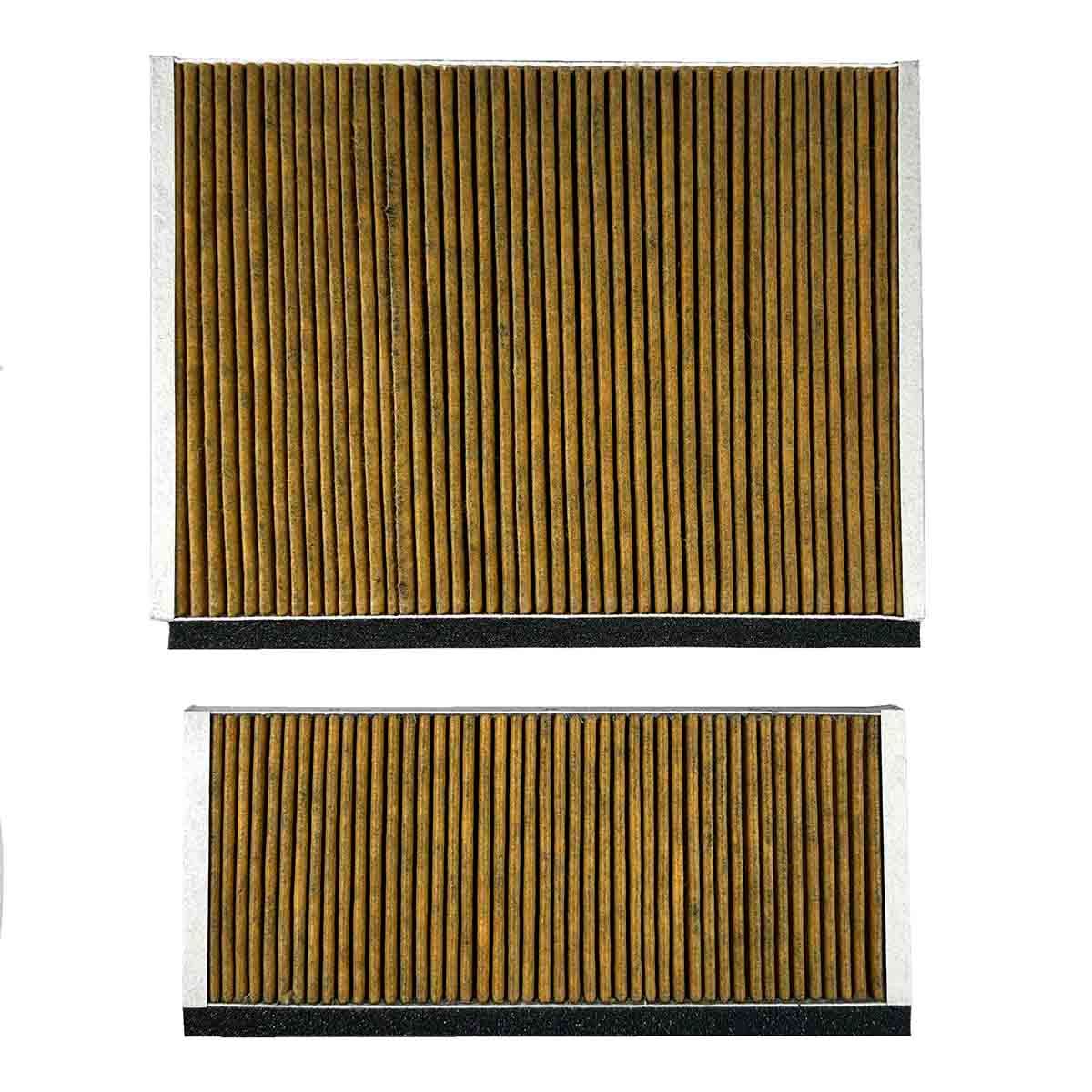 Zwei rechteckige Luftfilter. Jeder Filter hat vertikales braunes, schilfartiges Material in einem weißen Rahmen. Schwarzer Schaumstoff unten.
