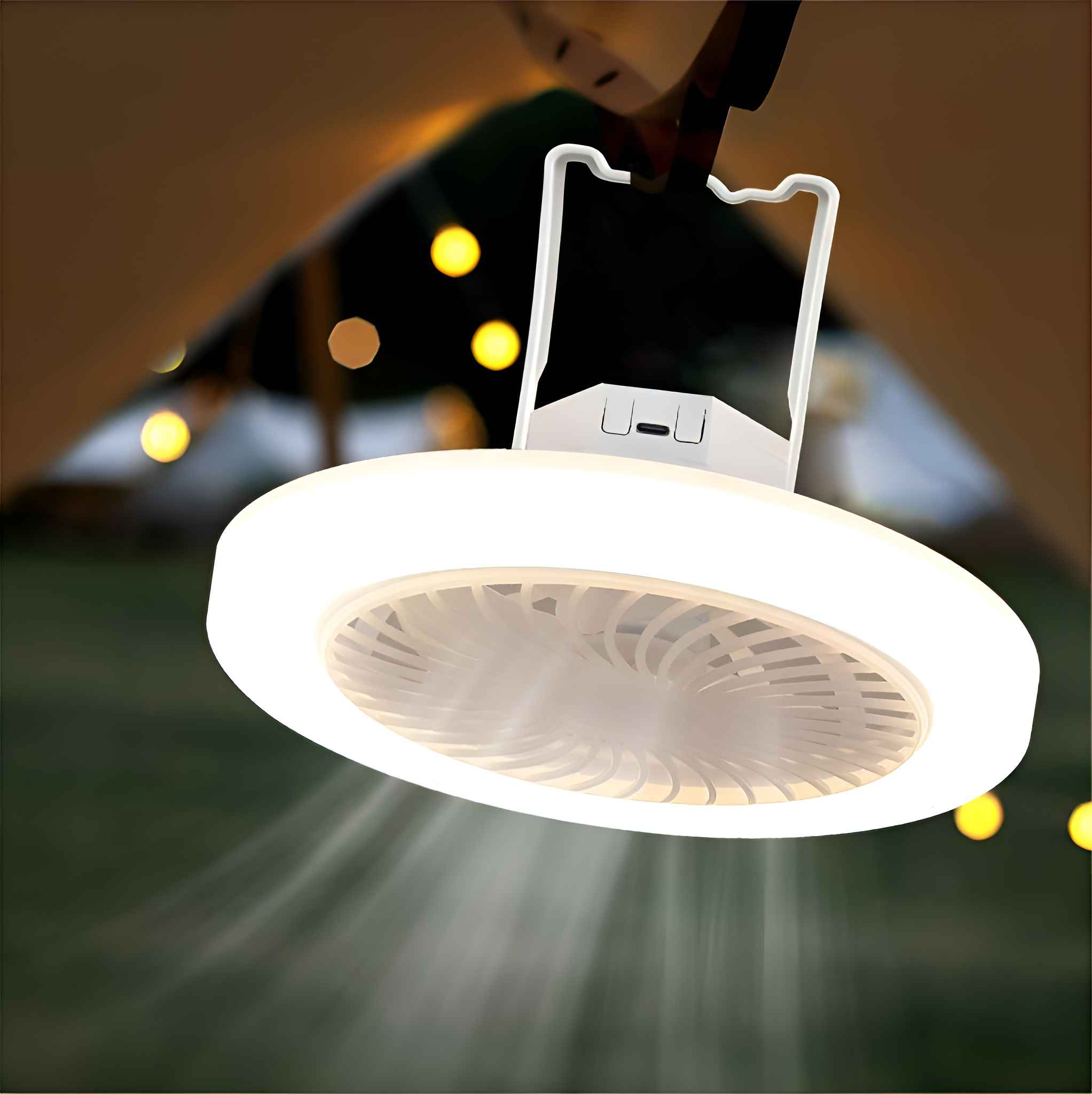 Ein weißer, runder Campingventilator mit eingebautem Licht hängt an einem Zelt. Das Licht scheint nach unten. Der Hintergrund hat Bokeh-Lichter.