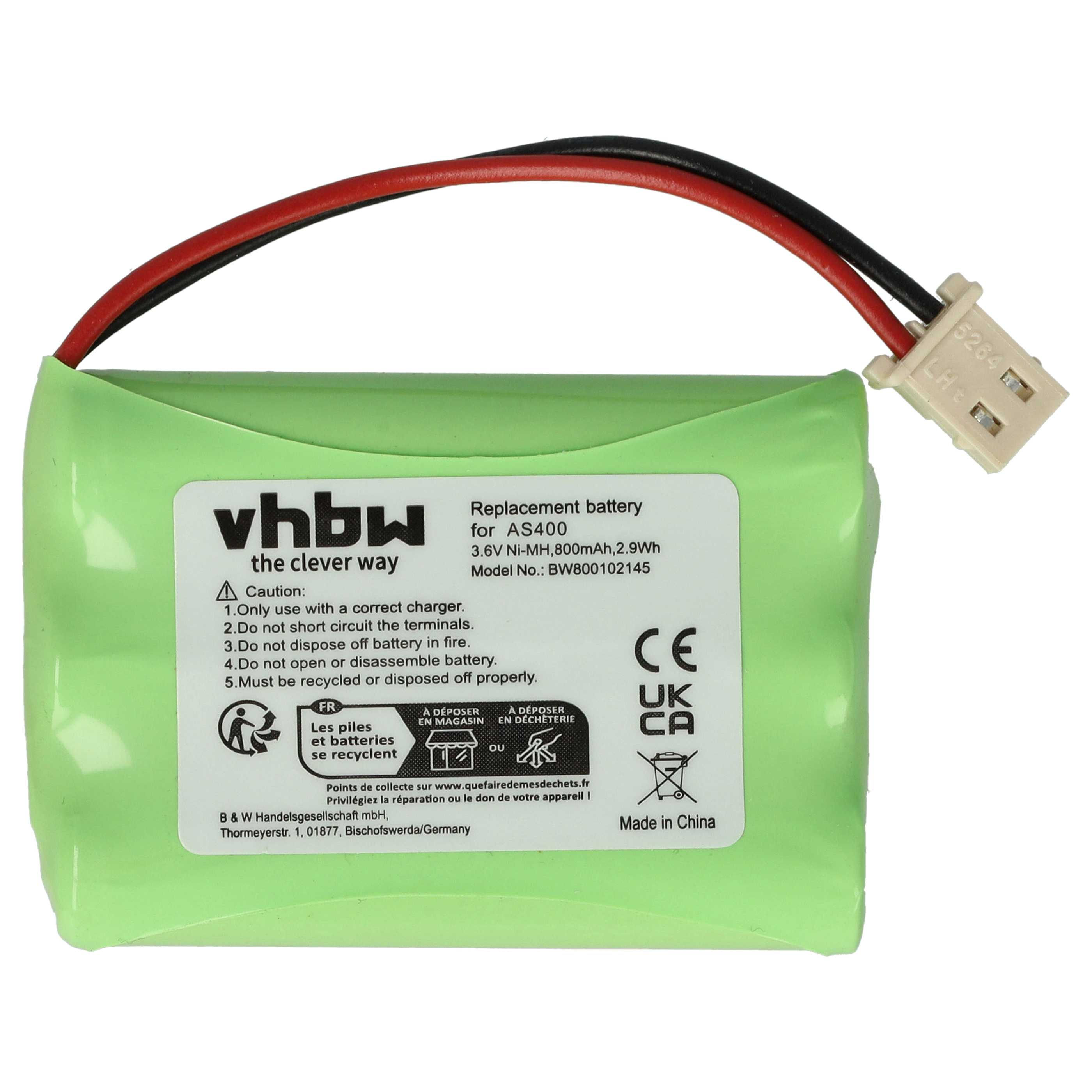 Eine grüne Batterie mit roten und schwarzen Drähten, die an einem weißen Stecker befestigt sind. Text auf der Batterie.