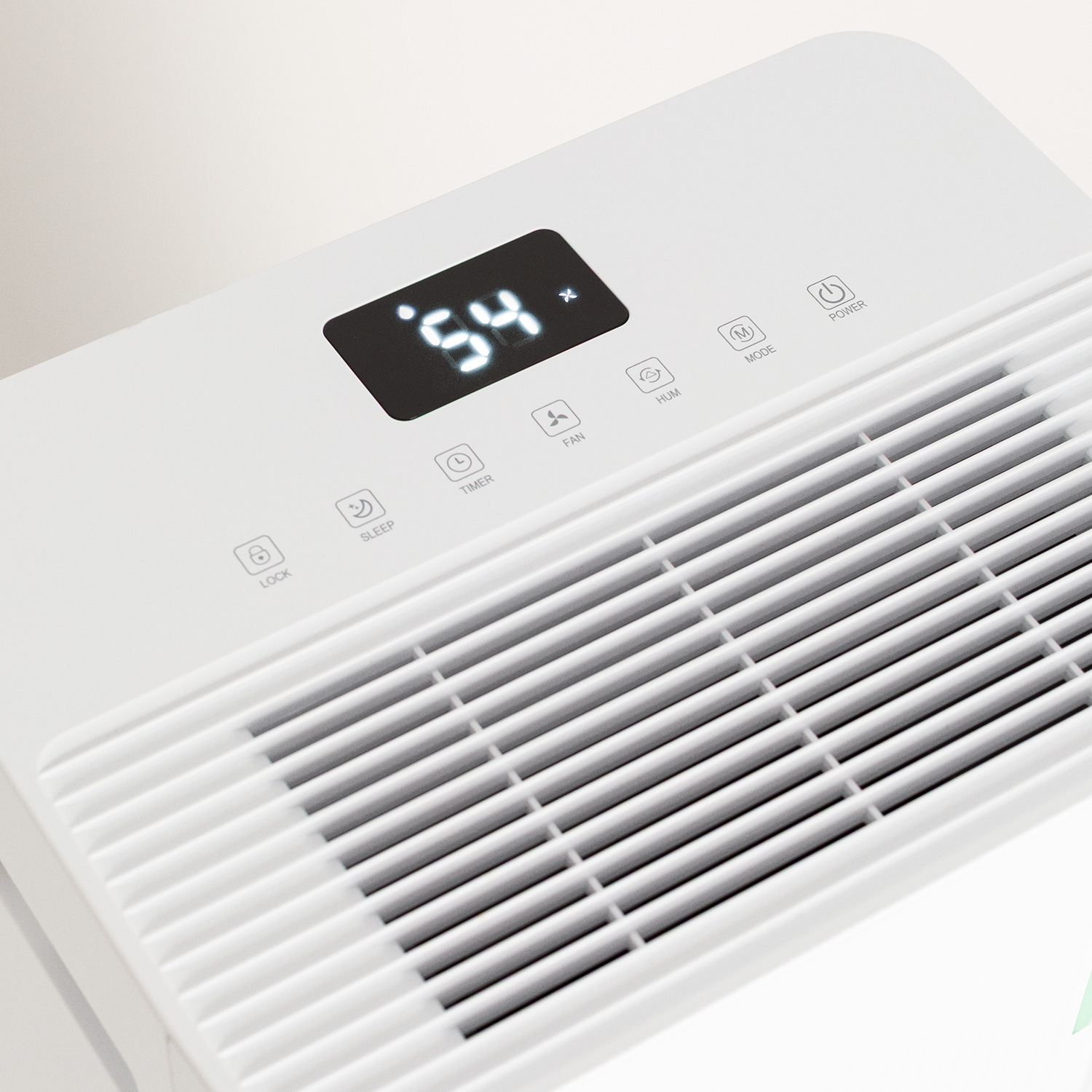 Purificador de aire blanco con pantalla digital '54'. Botones para temporizador, ventilador, modo y encendido. Rejilla inferior.