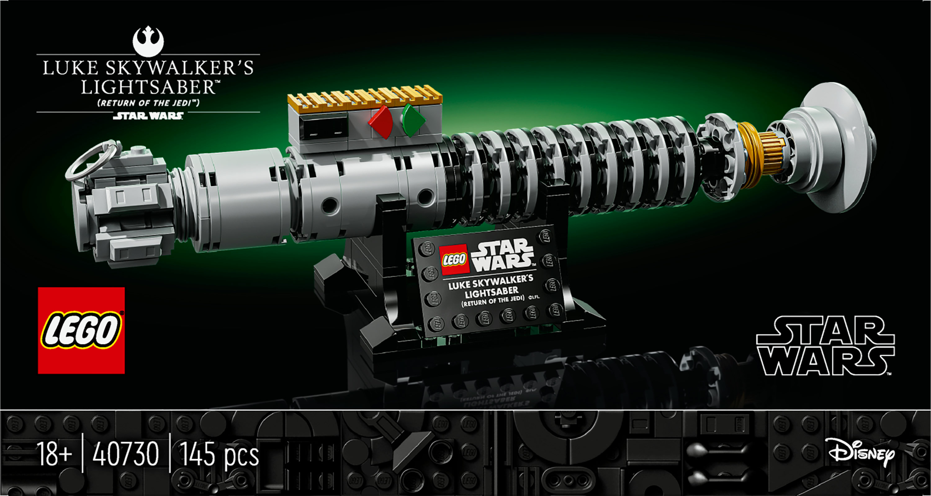 Luke Skywalker'ın ışın kılıcının Lego seti, gümüş ve siyah, yeşil ve kırmızı detaylarla, siyah bir stant üzerinde, Star Wars temalı.
