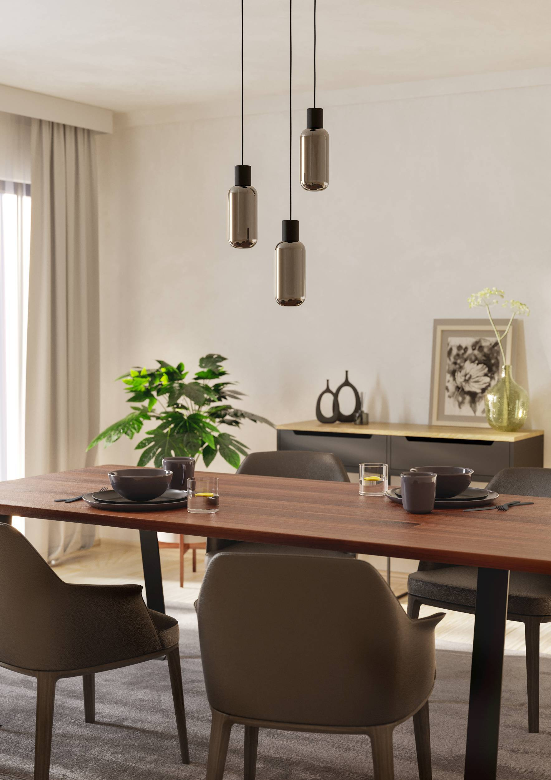 Sala da pranzo con tavolo in legno, sedie e lampade a sospensione. Visibili anche una pianta, decorazioni e una finestra con tende.
