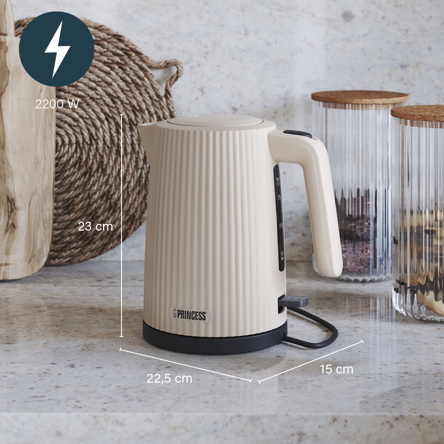 Beżowy czajnik elektryczny Princess z czarną podstawą, o wymiarach 23x22,5x15 cm, obok słoików i plecionej maty.
