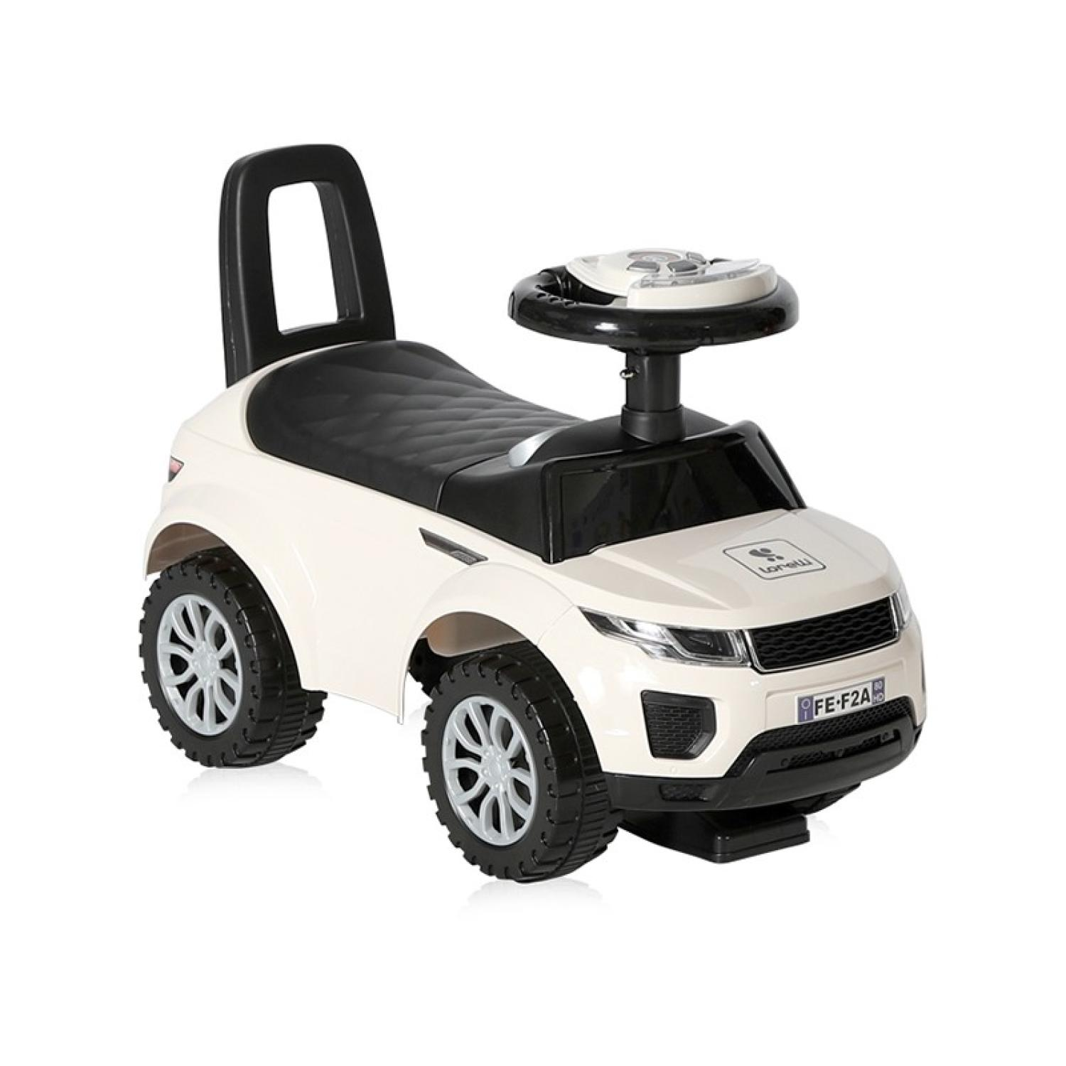 Un coche de juguete blanco y negro para montar. Tiene volante, asiento y cuatro ruedas. El coche está sobre un fondo blanco.