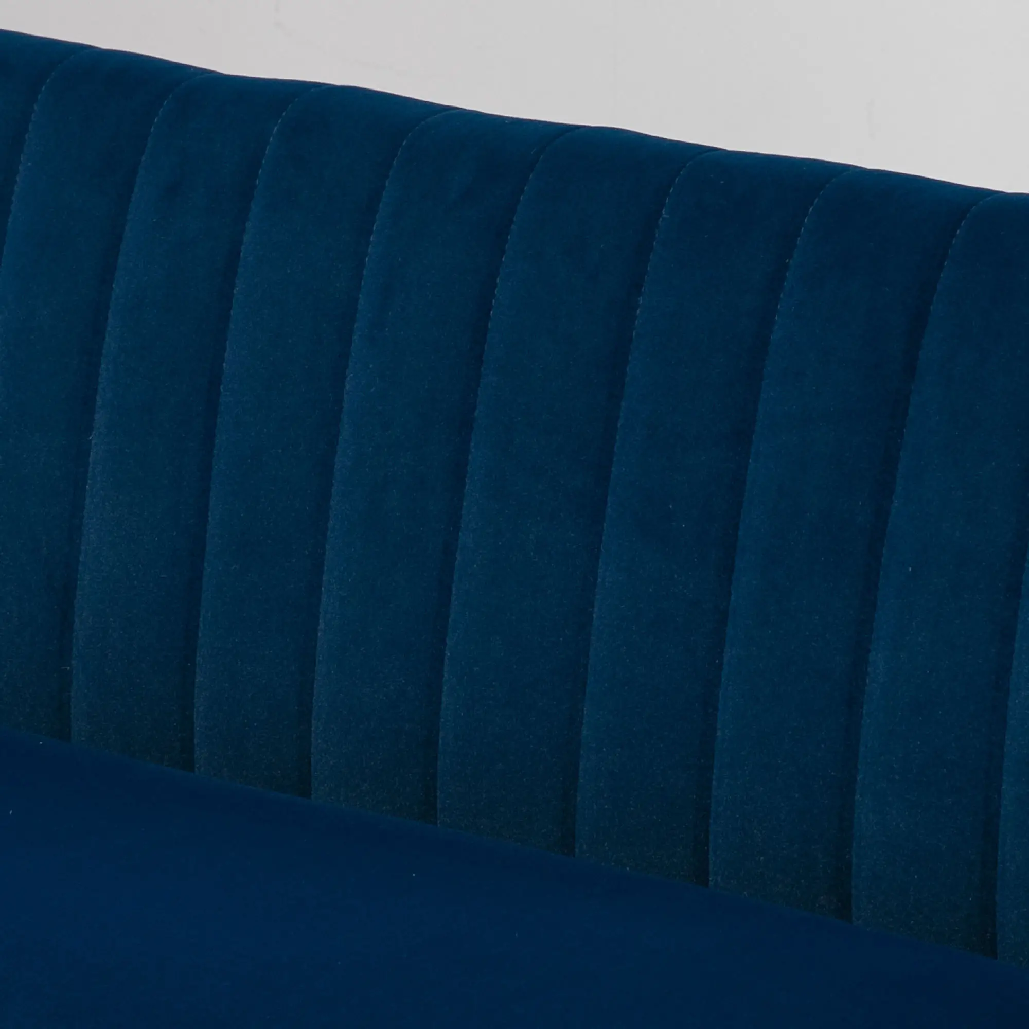 Nahaufnahme einer marineblauen, gepolsterten Kopfstütze. Vertikale, gepolsterte Paneele erzeugen eine strukturierte Oberfläche.