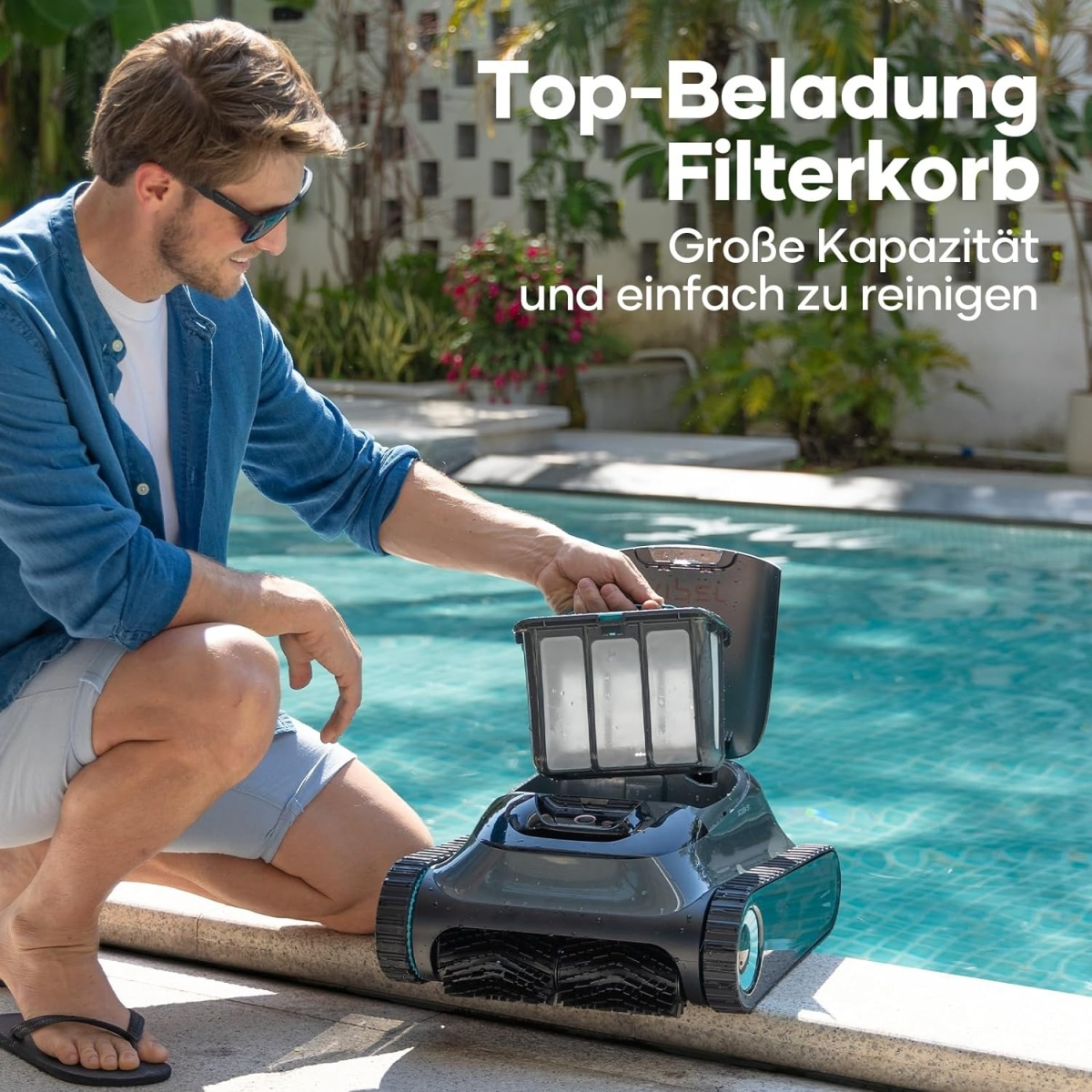Un hombre abre la cesta del filtro de un limpiador de piscinas robótico cerca de una piscina. El texto superior dice: Top-Beladung Filterkorb.