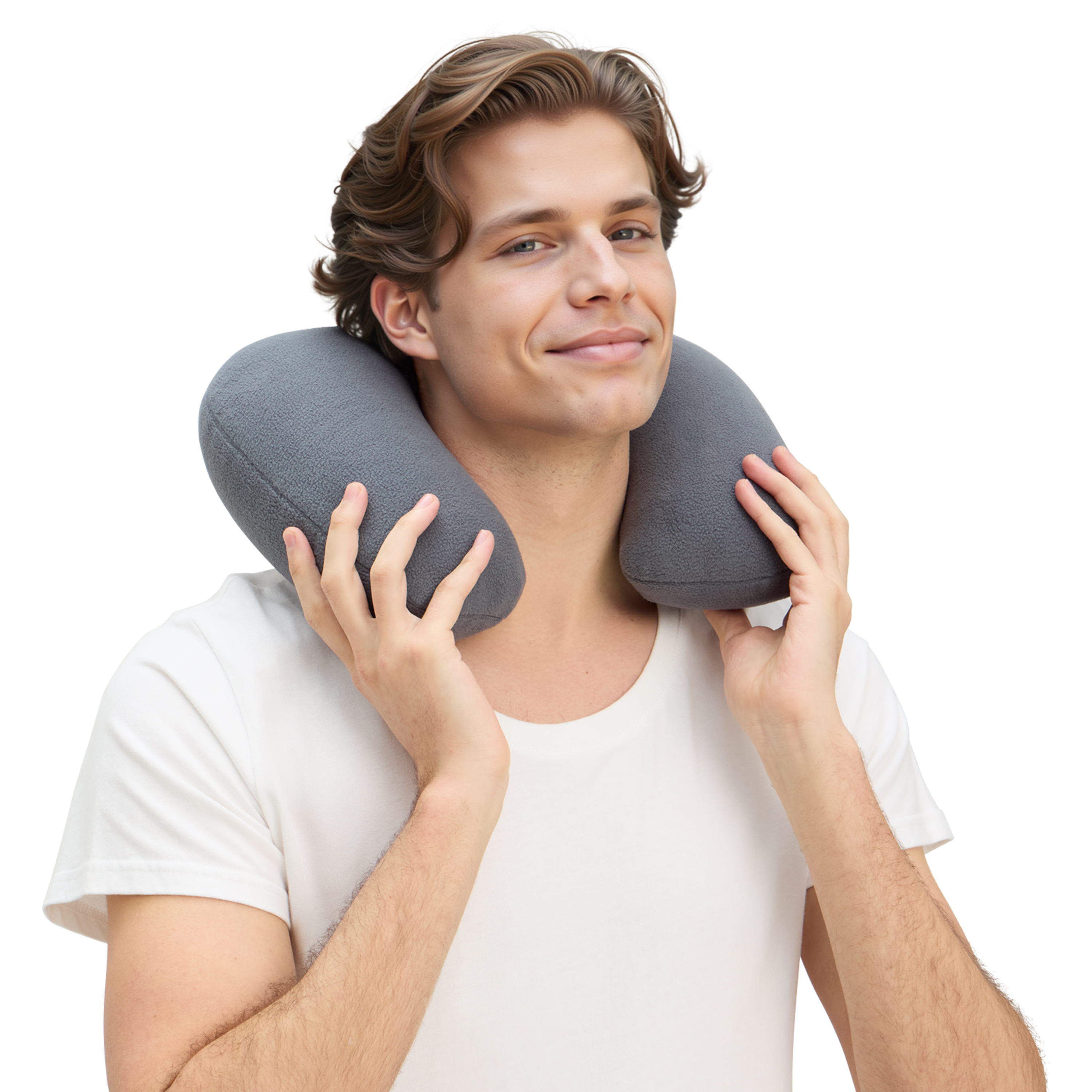 Un hombre con una almohada gris para el cuello sonríe a la cámara. Lleva una camiseta blanca sobre un fondo blanco.