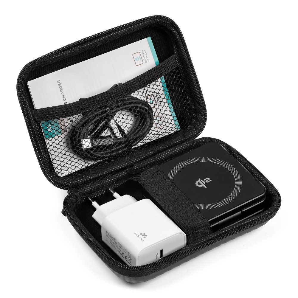 Otwarta czarna walizka podróżna, pokazująca ładowarkę, kabel i dokumentację. Widoczna jest biała ładowarka i czarna podkładka do ładowania bezprzewodowego.